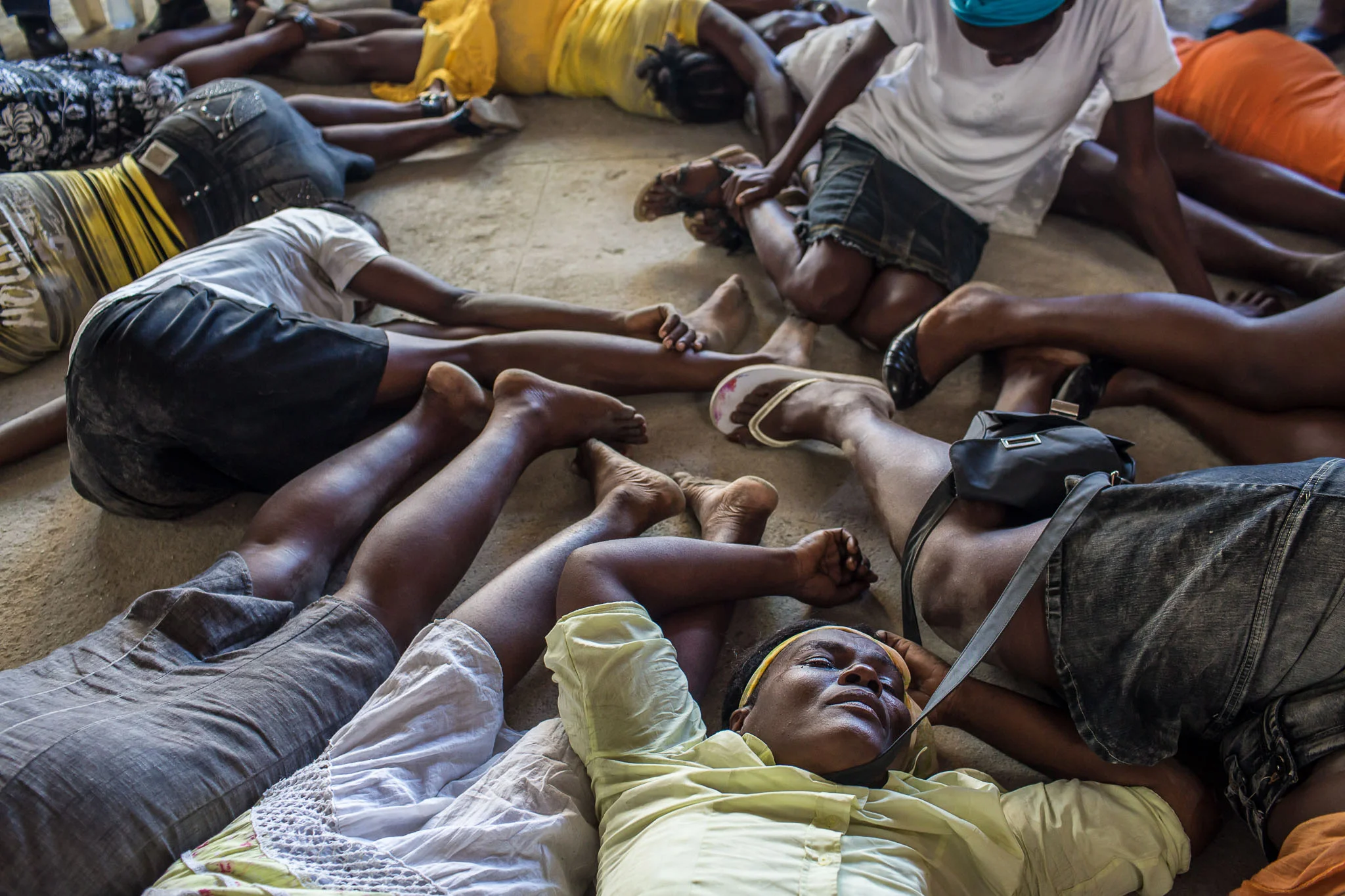 Worshipers who have been overcome with religious fervor lie in a heap on the floor at L'Eglise Evangelique Piscine de Bethesda, the church of televangelist Marcorel Zidor, on Saturday, December 20, 2014 in Port-au-Prince, Haiti. Pastor Zidor attracts a large audience with his emotional services and miracle medical cures of dubious theraputic value.