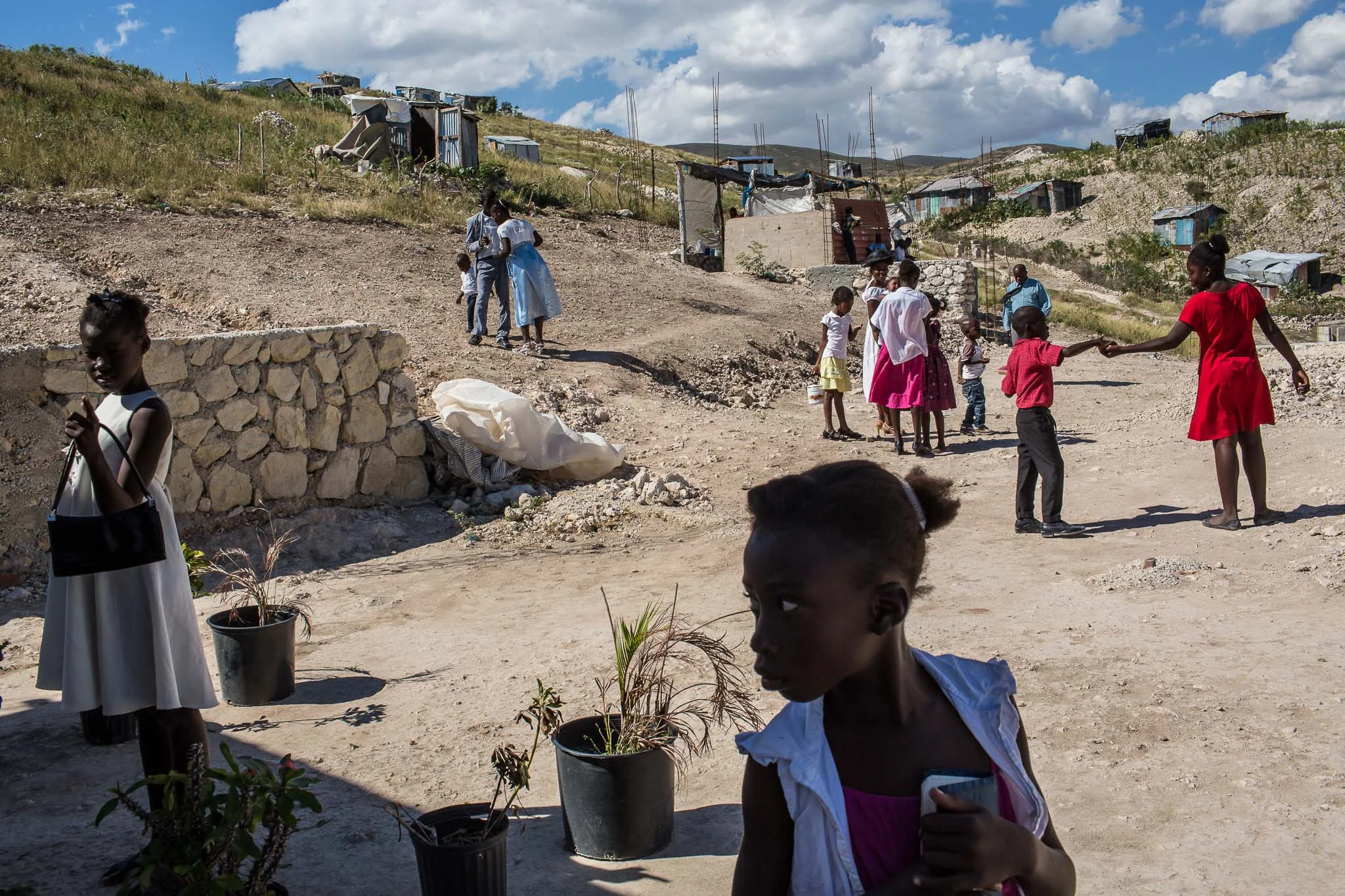 Worshipers prepare to leave following services at Church of God for Fighting Pentecostal Church on the edge of the Corail-Cesselesse camp for people displaced by the 2010 earthquake on Sunday, December 21, 2014 in Port-au-Prince, Haiti. The camp and surrounding areas are home to tens of thousands of people, many of whom live in makeshift shacks in a barren landscape with little or no access to jobs or resources.