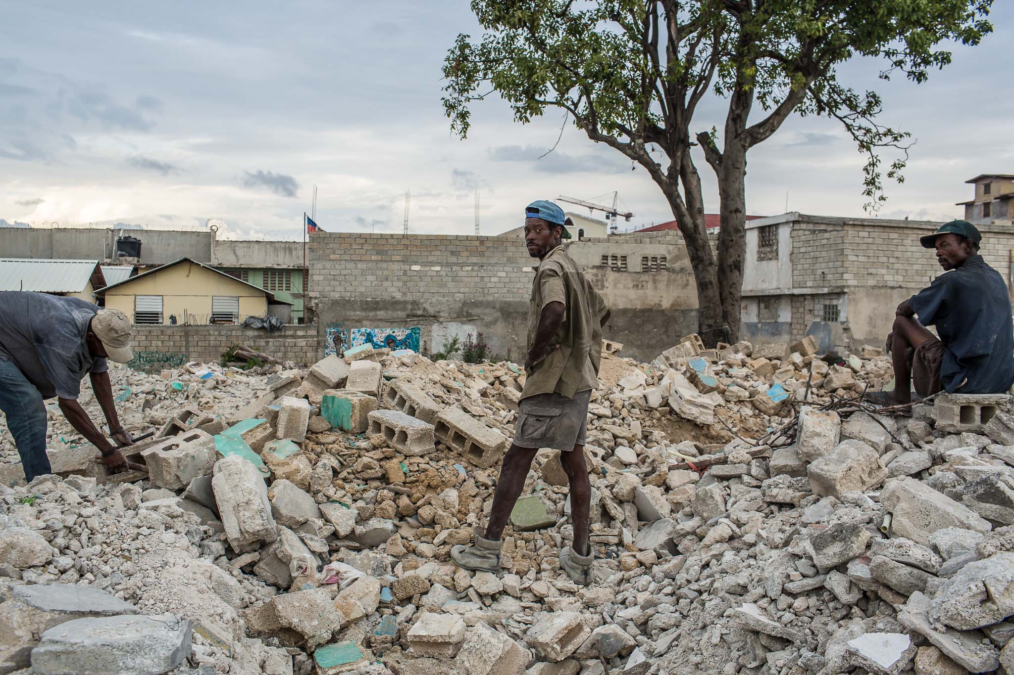  Men salvage usable concrete blocks from the rubble of demolished buildings on Sunday, December 14, 2014 in Port-au-Prince, Haiti. Several square blocks of residences and small businesses have been demolished near the city center, with no warning to 