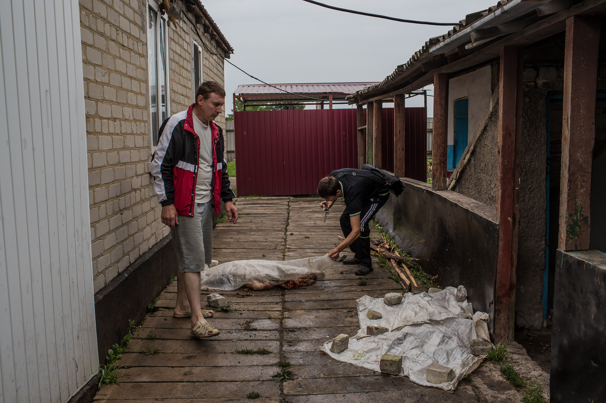  Men show the bodies of passengers from an Air Malaysia plane which landed next to a house on July 18, 2014 in Rassipnoye, Ukraine. Malaysia Airlines flight MH17 travelling from Amsterdam to Kuala Lumpur has crashed on the Ukraine/Russia border near 