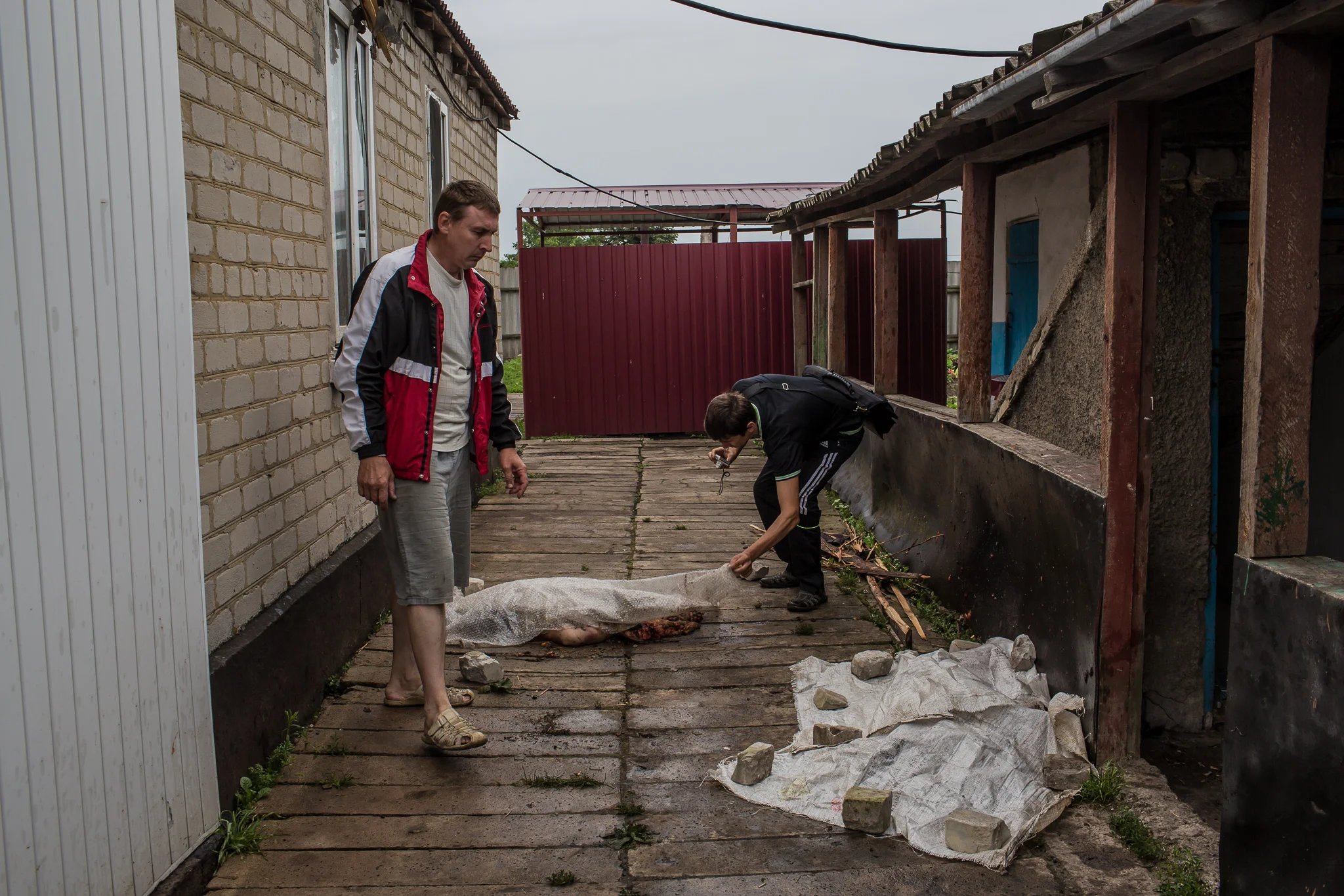 Men show the bodies of passengers from an Air Malaysia plane which landed next to a house on July 18, 2014 in Rassipnoye, Ukraine. Malaysia Airlines flight MH17 travelling from Amsterdam to Kuala Lumpur has crashed on the Ukraine/Russia border near the town of Shaktersk. The Boeing 777 was carrying 298 people.