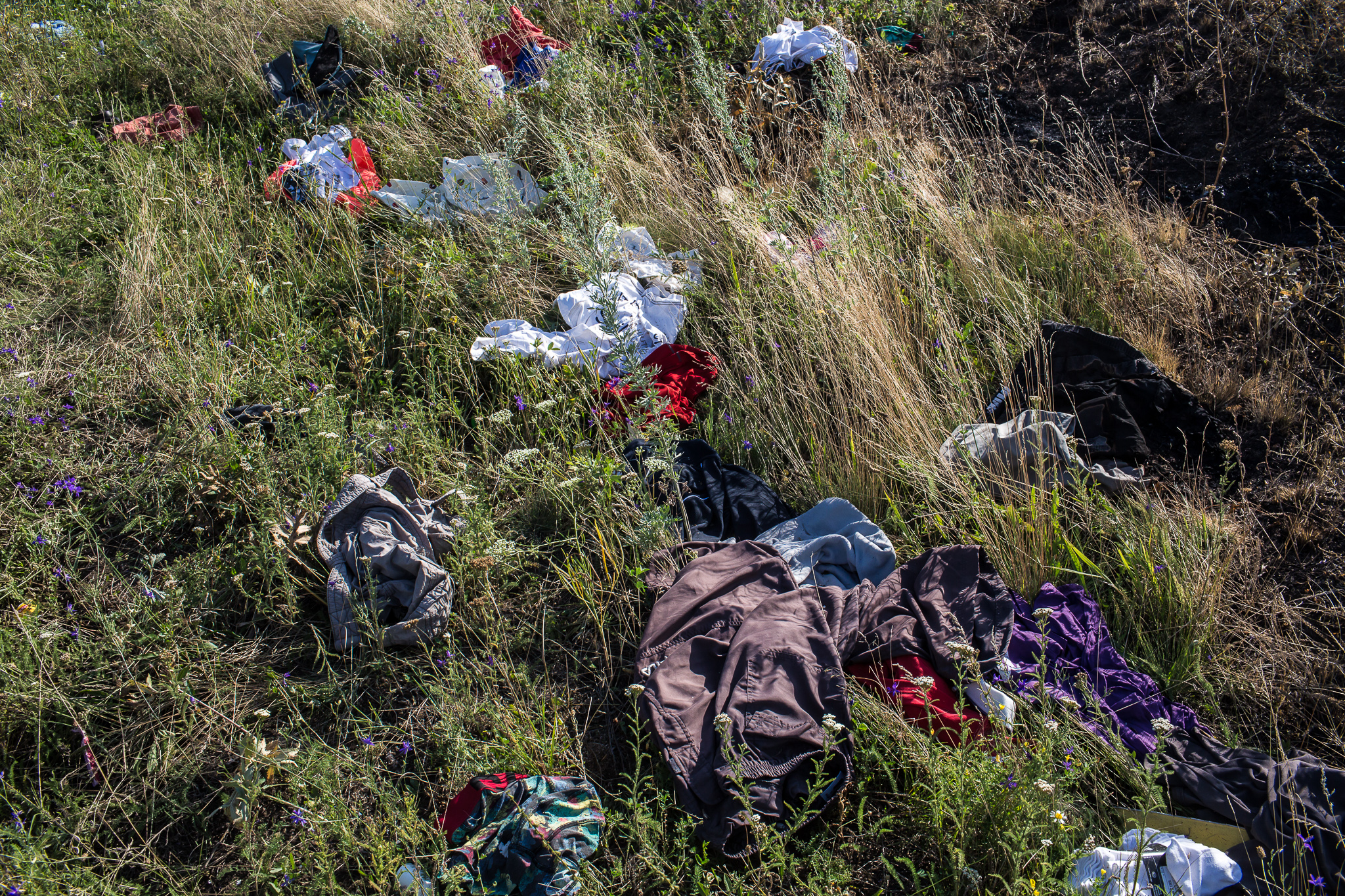  Clothing from the crash of Malaysia Airlines flight MH17 is strewn in the grass at the crash site on July 20, 2014 in Grabovo, Ukraine. The flight was traveling from Amsterdam to Kuala Lumpur when it crashed killing all 298 on board including 80 chi