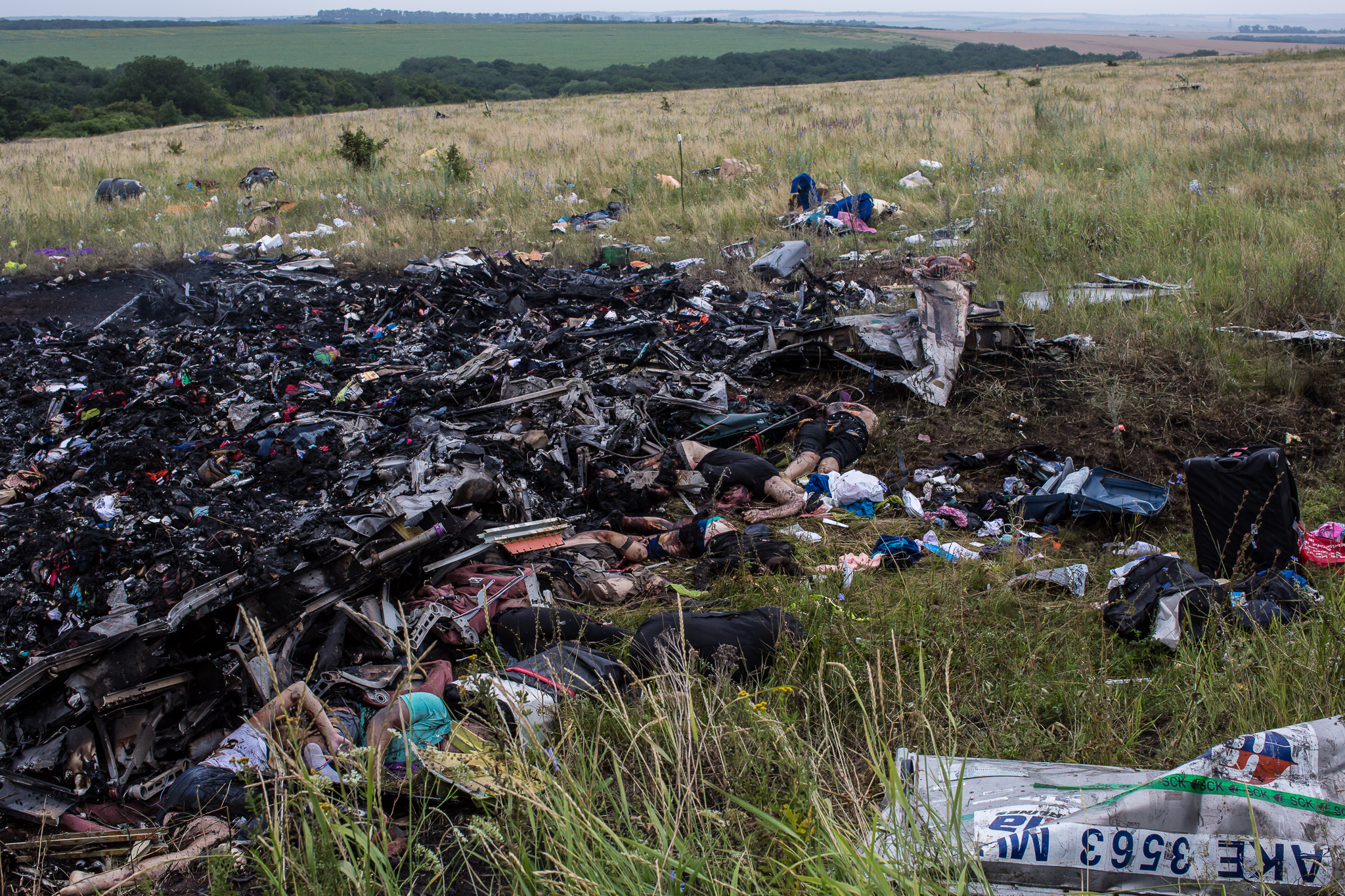  The bodies of victims of the crash of Malaysia Airlines flight MH17 lie among burned wreckage in a field on July 18, 2014 in Grabovo, Ukraine. Air Malaysia flight MH17 travelling from Amsterdam to Kuala Lumpur has crashed on the Ukraine/Russia borde