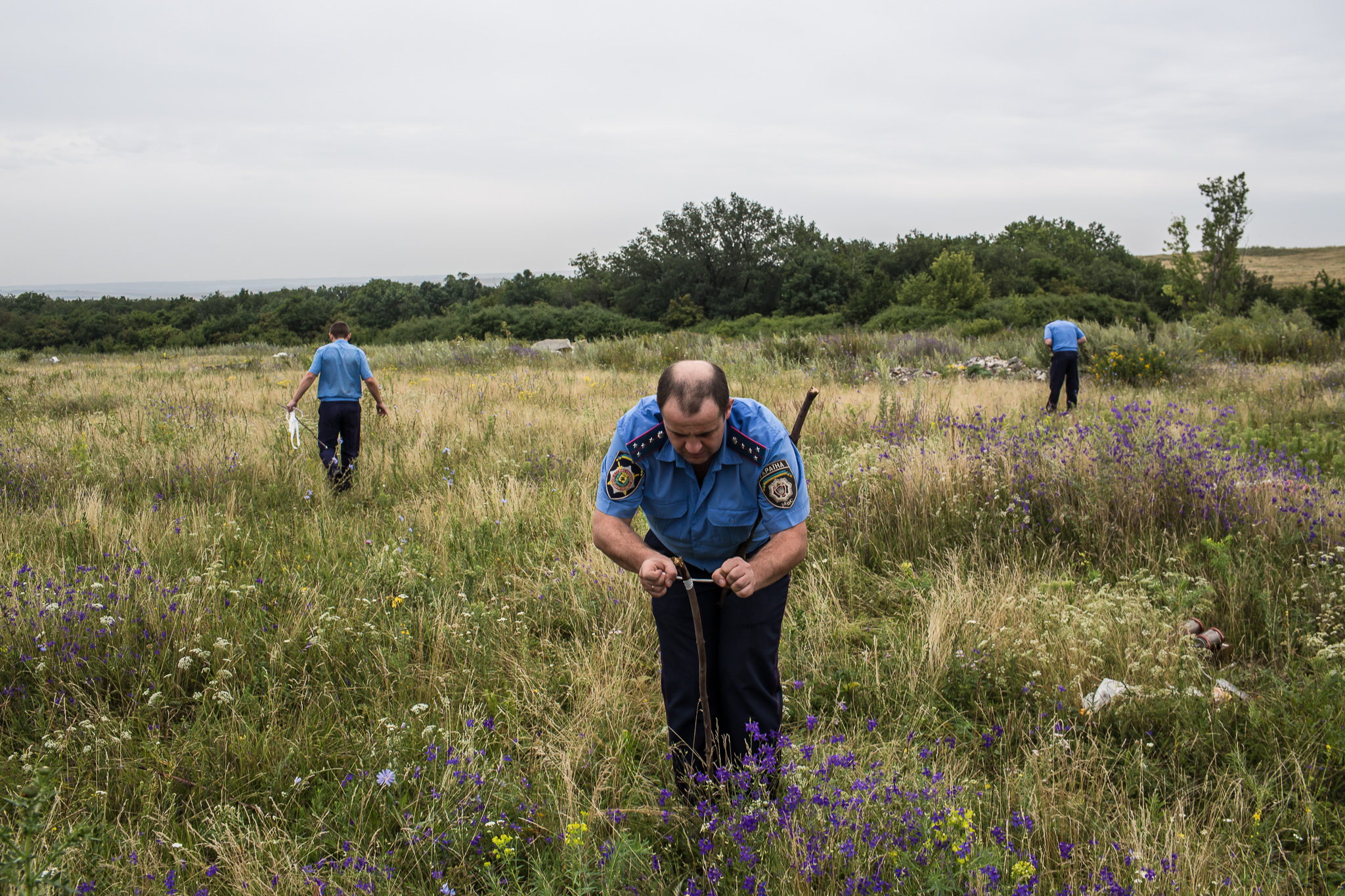  A Ukrainian Emergencies Ministry worker ties a white ribbon to a stake to mark human remains found in a field after a commercial passenger plane was shot from the sky by a missile the previous day on July 18, 2014 in Grabovo, Ukraine. Malaysia Airli