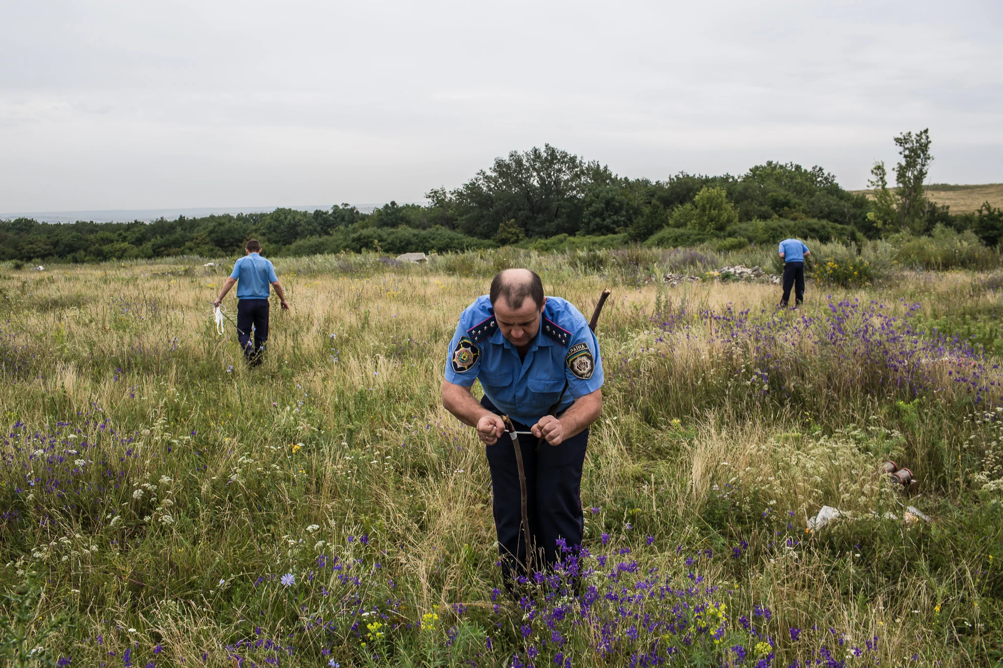 A Ukrainian Emergencies Ministry worker ties a white ribbon to a stake to mark human remains found in a field after a commercial passenger plane was shot from the sky by a missile the previous day on July 18, 2014 in Grabovo, Ukraine. Malaysia Airlines flight MH17 travelling from Amsterdam to Kuala Lumpur has crashed on the Ukraine/Russia border near the town of Shaktersk. The Boeing 777 was carrying 298 people.