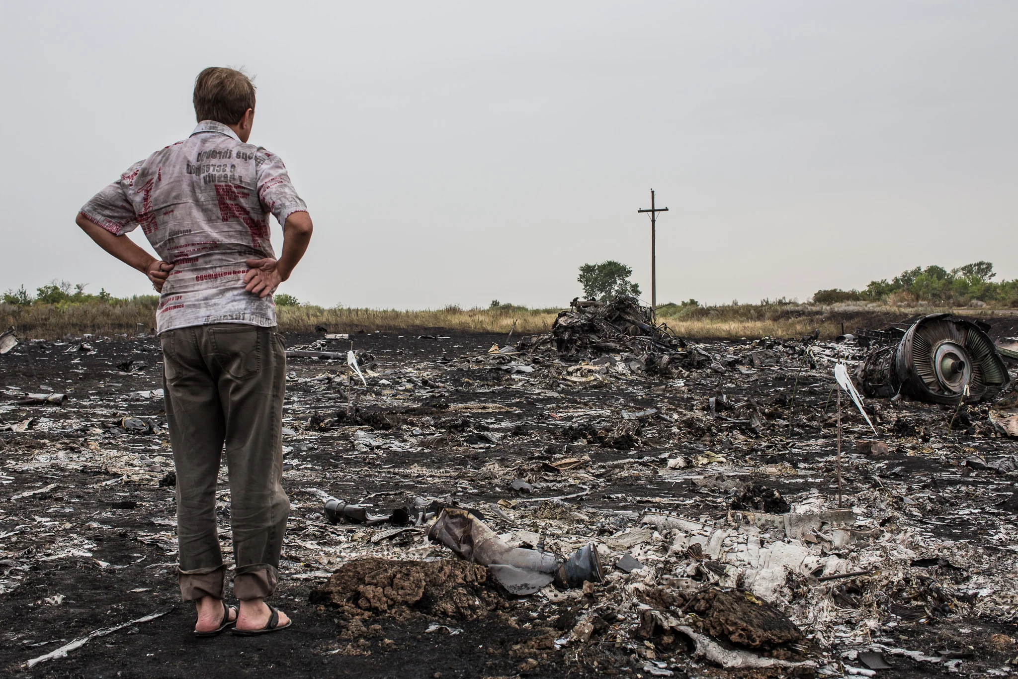 A man looks at debris from the crash of Malaysia Airlines flight MH17 on July 18, 2014 in Grabovo, Ukraine. Malaysia Airlines flight MH17 travelling from Amsterdam to Kuala Lumpur has crashed on the Ukraine/Russia border near the town of Shaktersk. The Boeing 777 was carrying 298 people.