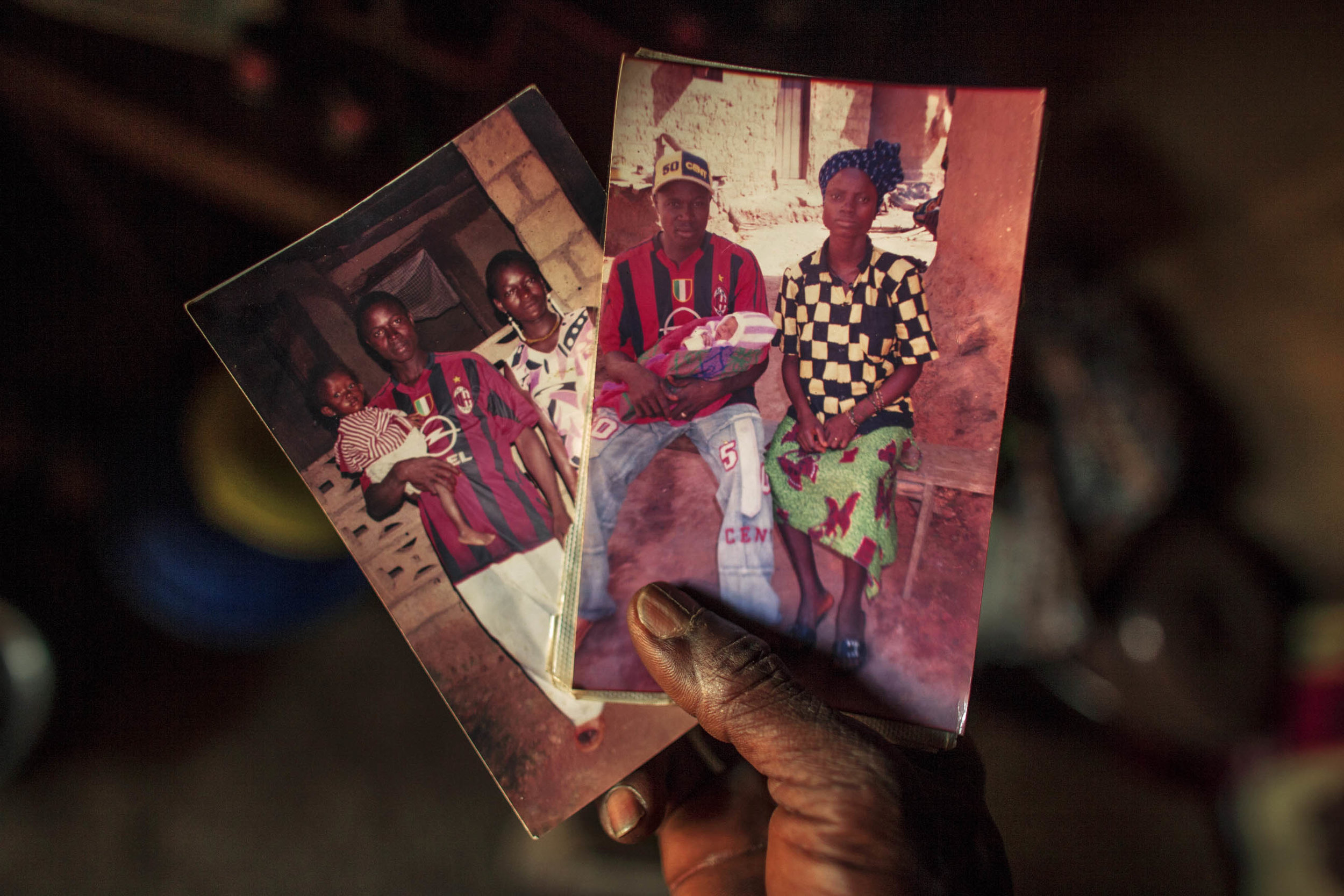  Etienne shows the few photographs he has of his late wife and son. (Photo by Pete Muller/Prime for National Geographic) 