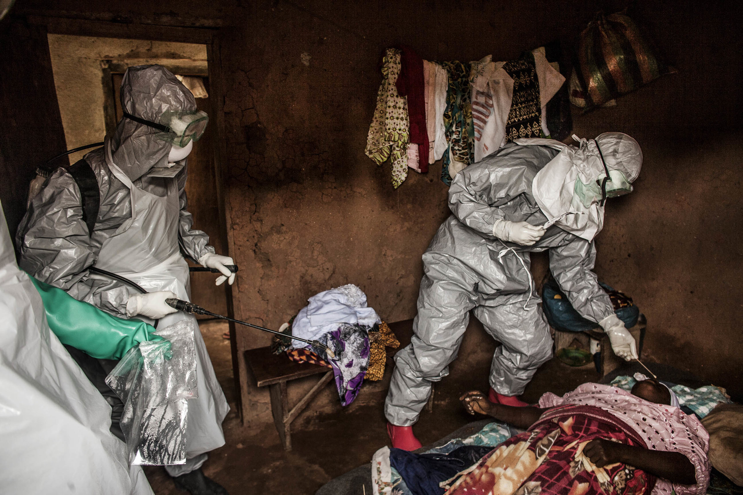  Members of a Red Cross burial team take samples from a   woman suspected of dying of Ebola in the village of Dia, near the border with Guinea, on Monday, August 18, 2014. So-called "safe burials," conducted by the International Federation of the Red