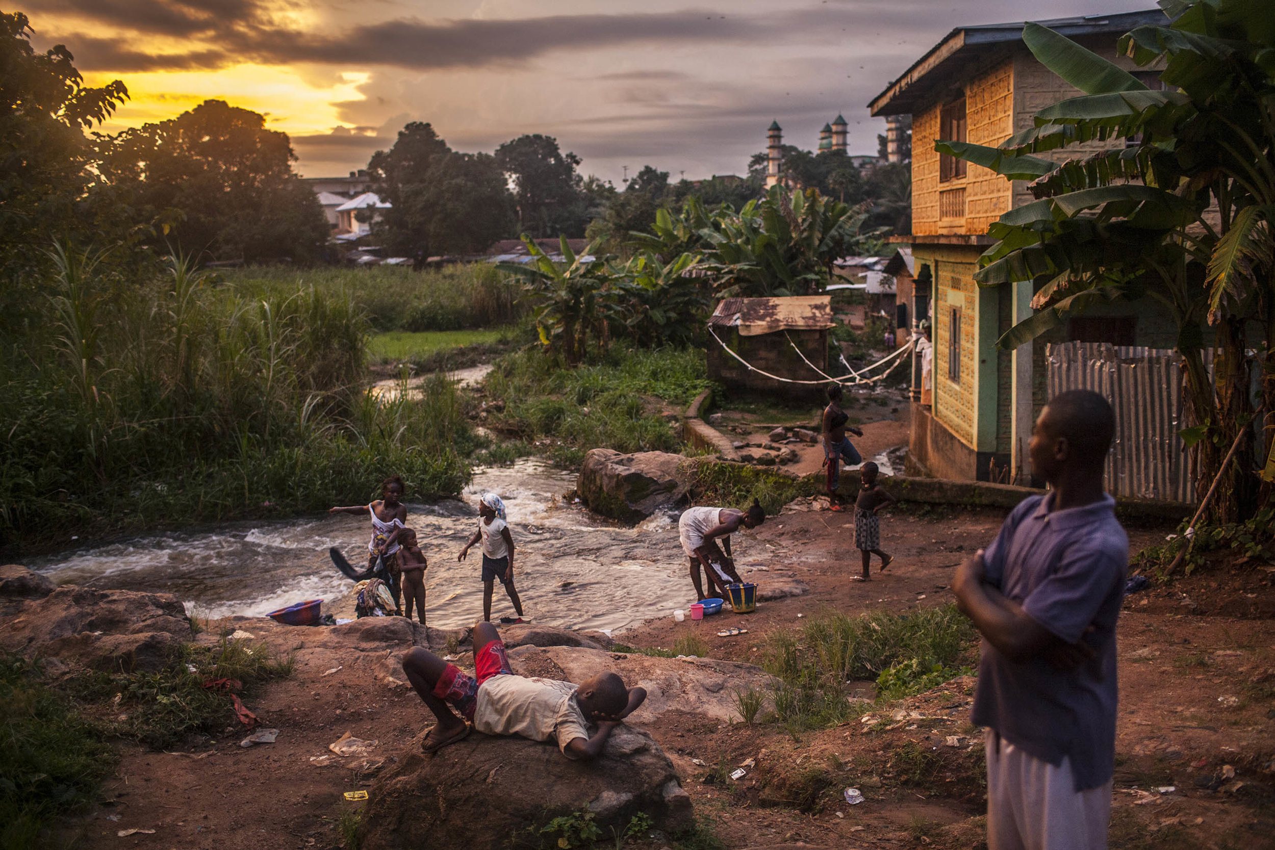  Residents of the town of Kailahun gather along a river at dusk on Tuesday, August 19, 2014. At the time, Kailahun district, in eastern Sierra Leone, was the most heavily affected by the ongoing Ebola outbreak, which originated across the nearby bord
