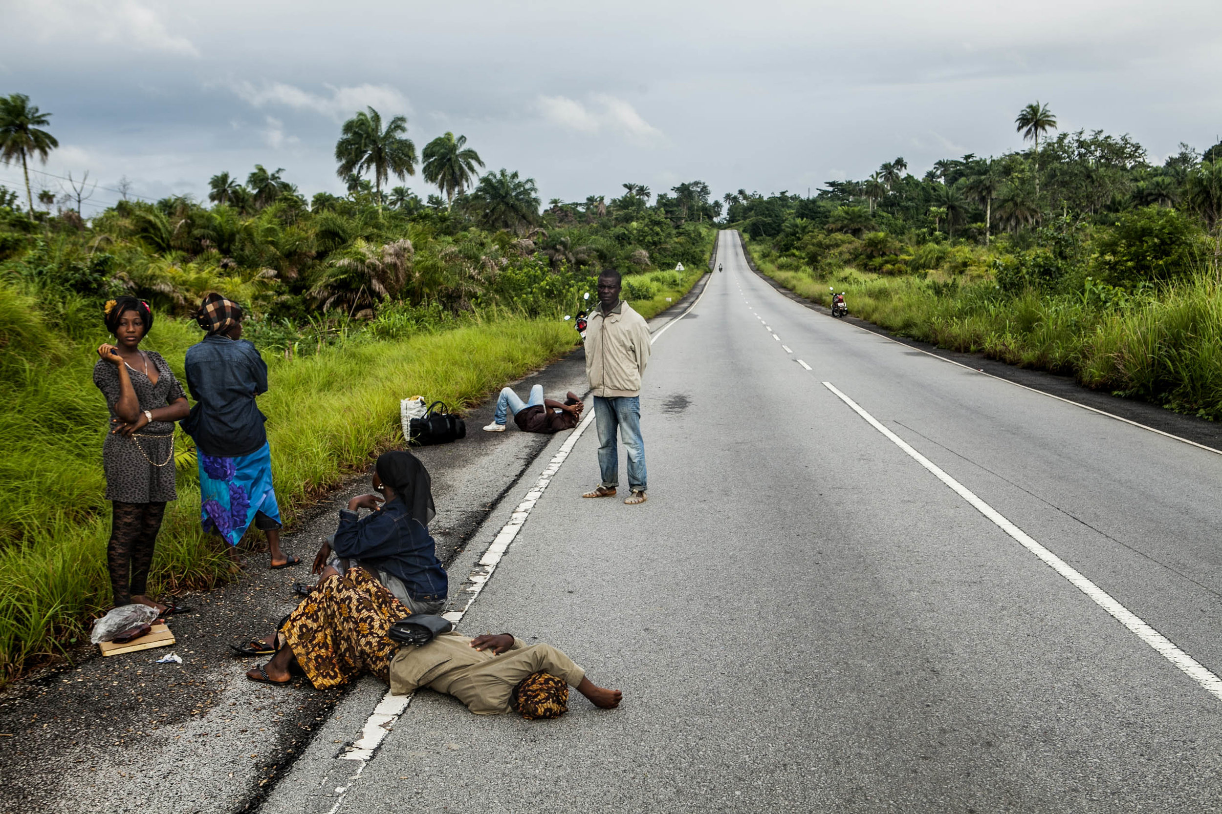  People who were denied passage at a checkpoint outside of Kenema wait on the roadside on Friday, August 22, 2014. Only those in possession of a government issued permit are allowed to cross Ebola quarantine checkpoints. (Pete Muller/Prime for the Wa