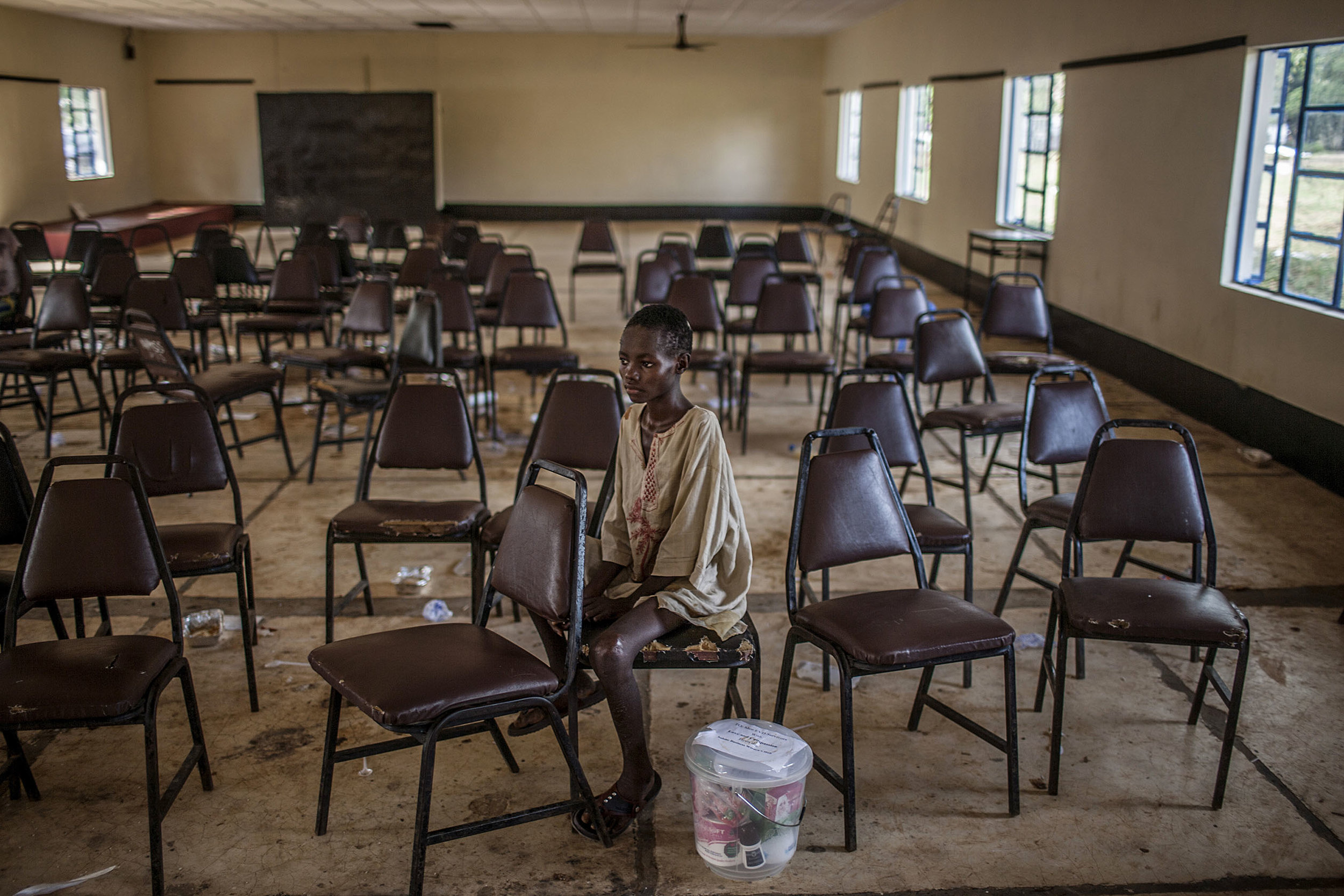  Molai Kamara, approximately 12 years old, sits alone following a discharge ceremony for Ebola survivors at the Hastings Ebola Treatment Center in Hastings, Sierra Leone on Saturday, November 29, 2014. While excitement buzzed outside as the other 55 
