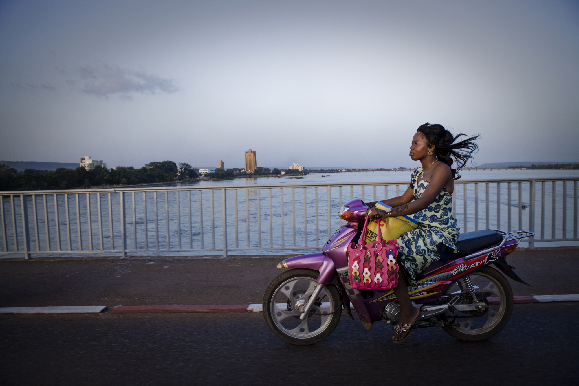  Bamako, Mali. SEPTEMBER 2013. A woman rides her motorcycle across the Niger River in Bamako, Mali. 

Summary: Mali, a predominantly Muslim country, has been known for it�s vibrant culture, rich ancient Islamic history, religious tolerance and joyful