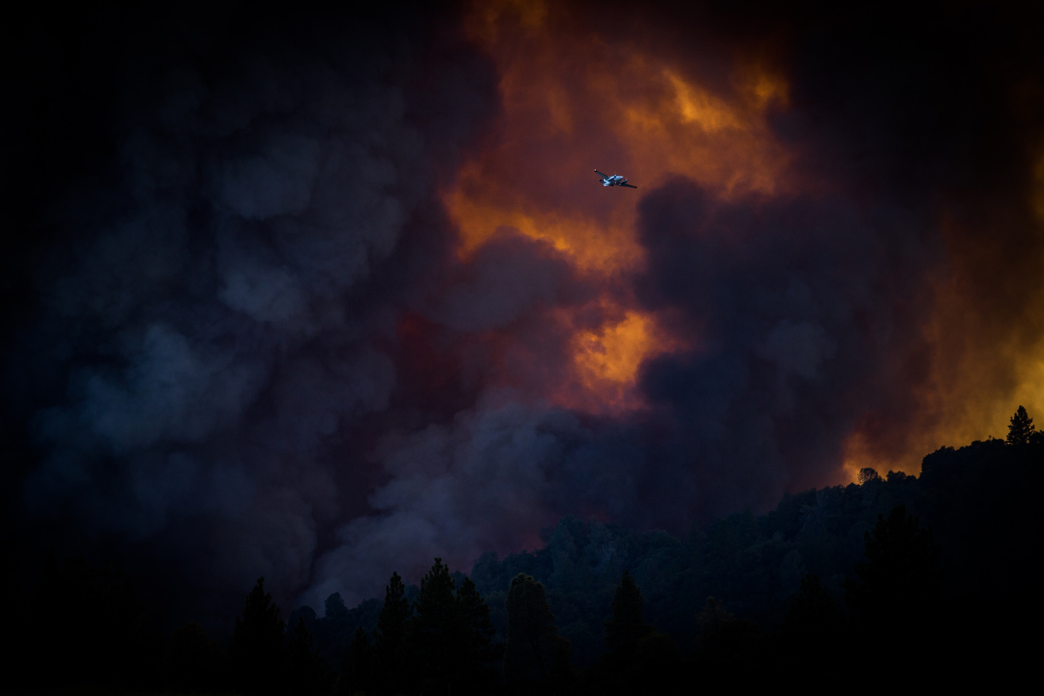  A spotter plane flies past the Sand Fire as it burns near Plymouth, California, July 26, 2014. 
The Sand Fire destroyed 20 homes and burned more than 4,200 acres near the town of Plymouth. 