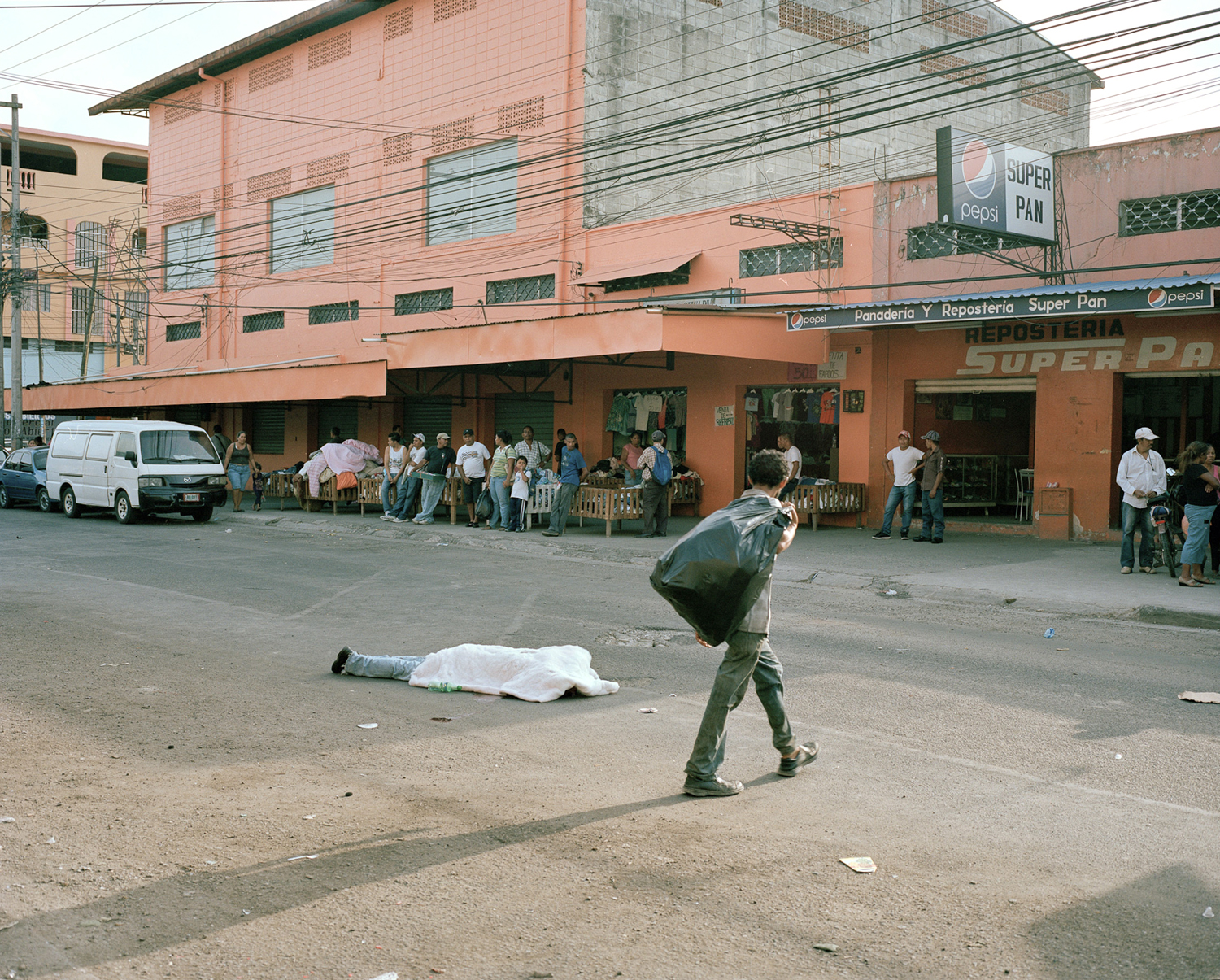  Merchants go about their business despite a body in the middle of the street in San Pedro Sula, Honduras. 