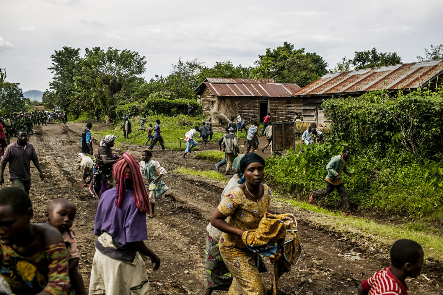  Congolese civilians scatter during a burst of heavy machine gun fire as FARDC troops advance toward Bunagana. 