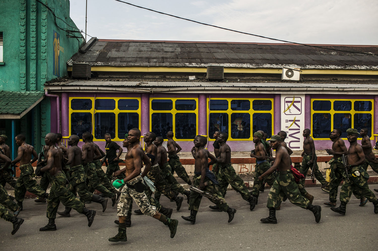  Congolese soldiers jog through downtown Goma on a Saturday morning. The weekly jogs are a relatively new feature, designed to inspire confidence and patriotism in the city's residents. 