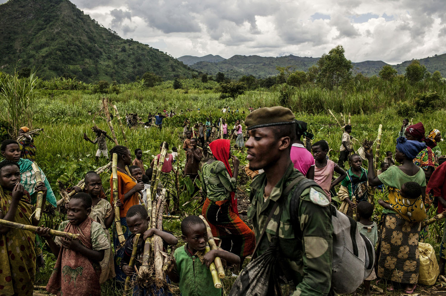  Civilians chop down sugar cane to pass along to Congolese soldiers as they advance up the mountainous road toward Bunagana, the last remaining stronghold of the M-23 rebels on Wednesday. 