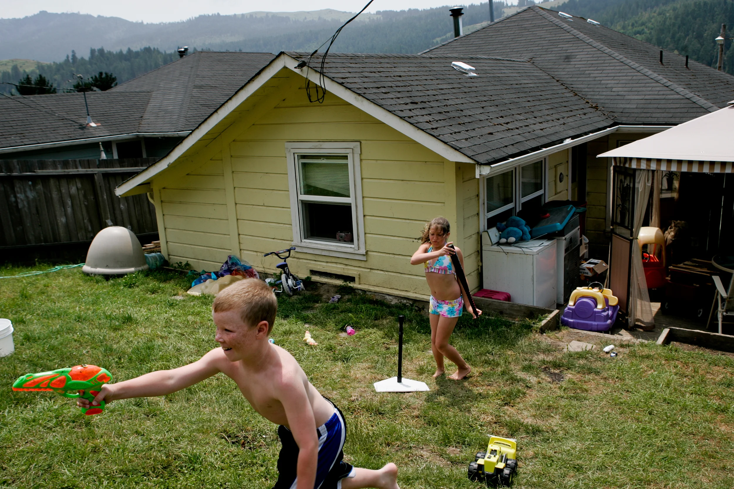 From left, Sheldon Eilers, 10, and Alexa Taylor play in the backyard of a Scotia, CA home on Tuesday, June 27, 2006. The town of Scotia in Northern California is a company town owned by the Pacific Lumber Company (PALCO), but that will change as the company will begin to sell the town.