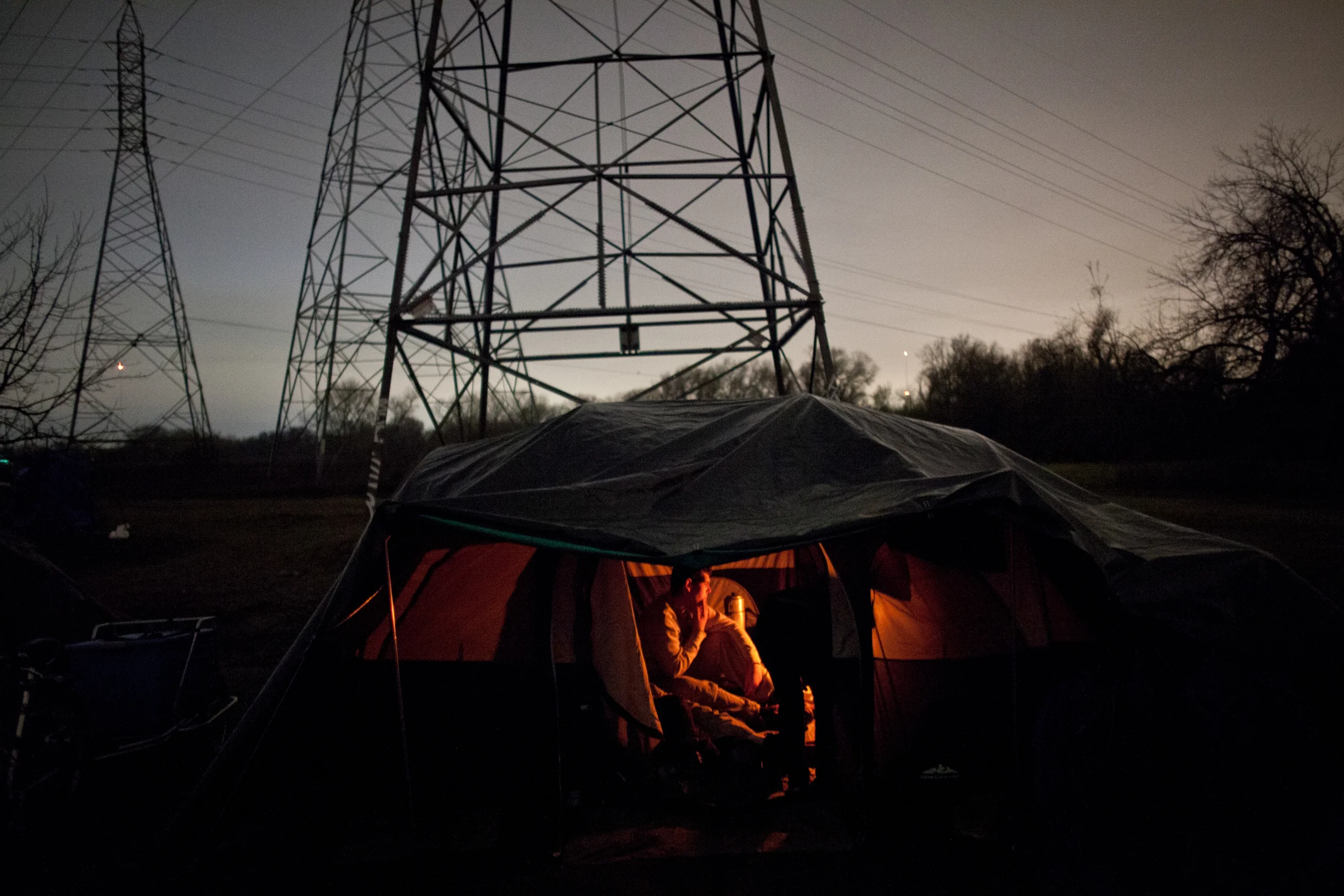 Campers stay warm in a tent heated by a propane burner at the SafeGround homeless tent camp in Sacramento, California.