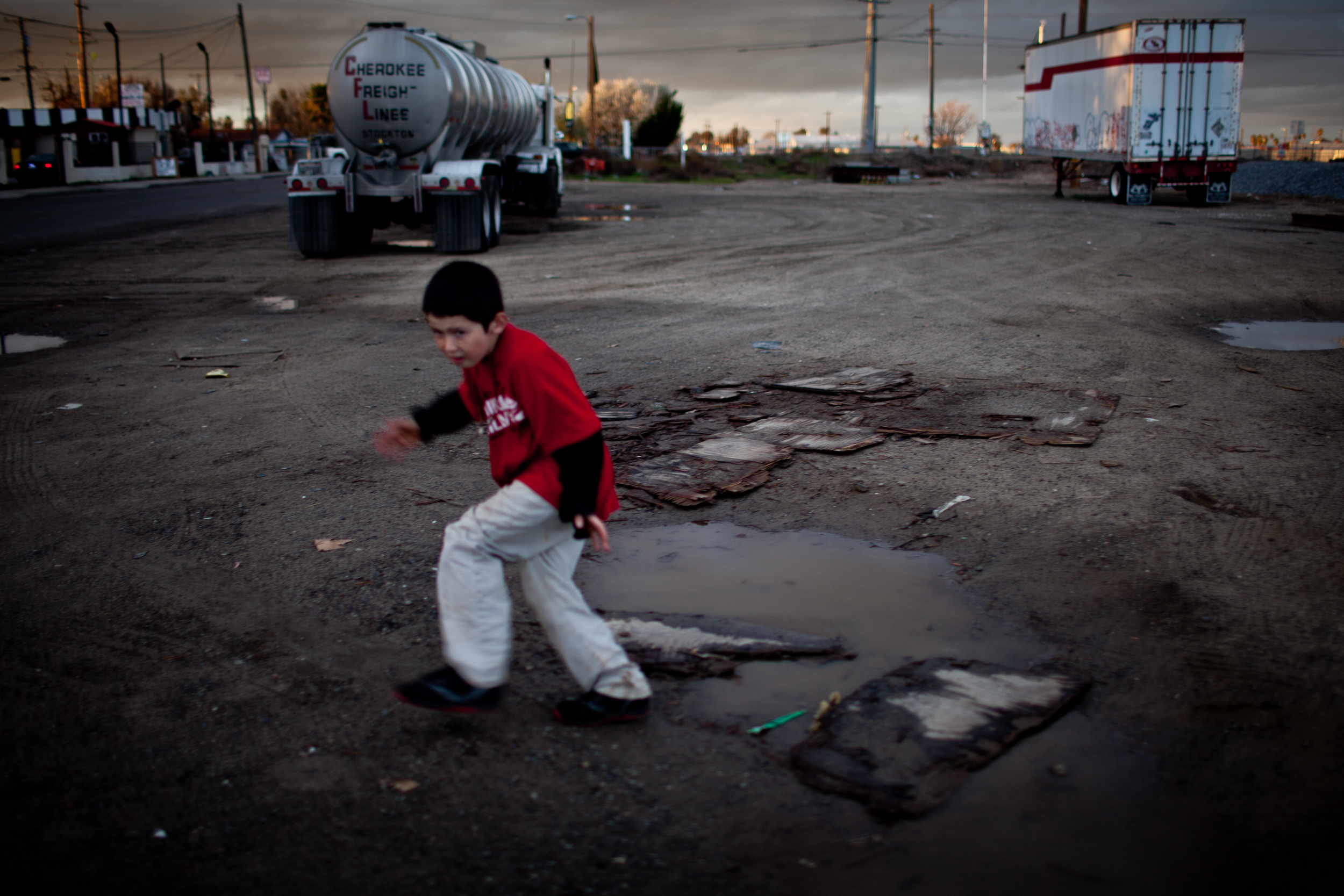  Ten-year-old Benito Tirjeron jumps over a puddle on the edge of the Parklawn neighborhood in Modesto, California. Across California there are hundreds of unincorporated communities like Parklawn. While a few are some of the state's richest areas; mo