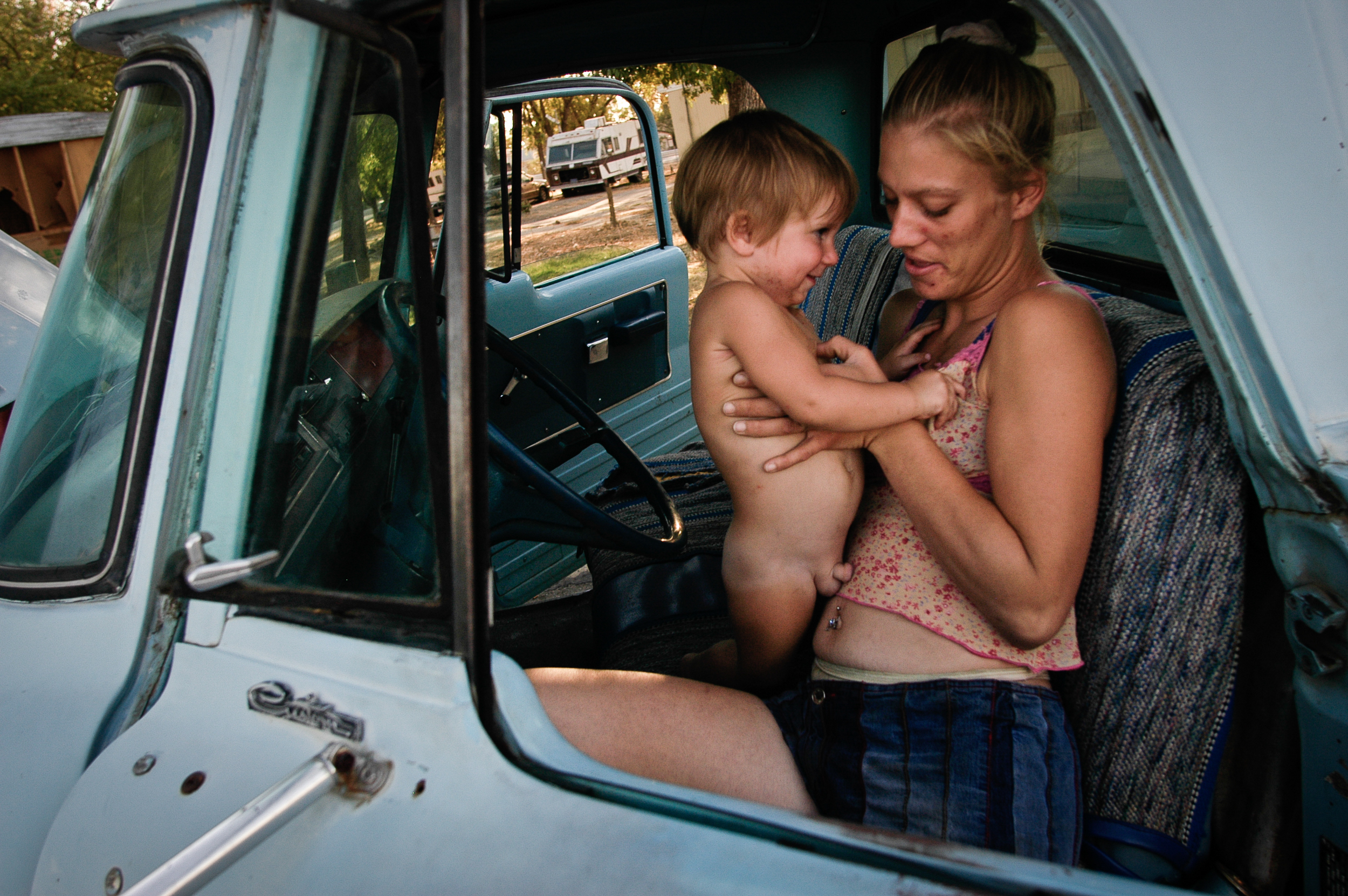  Amanda Barnes and her two-year-old son Brandon relax in their only vehicle, a pickup that is more often broken than not. 