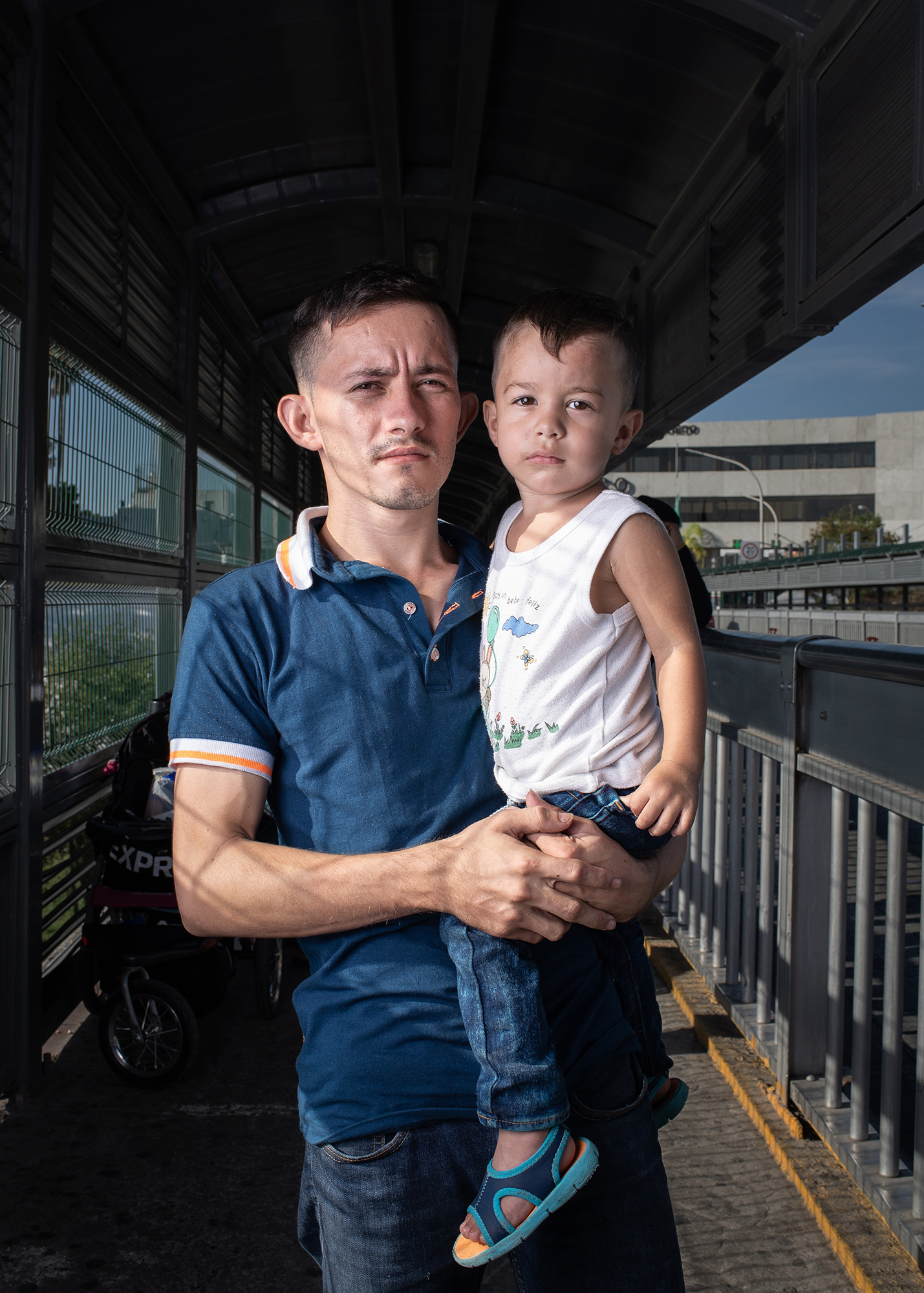  Portrait of Alfredo (26 years old) and his son Alex (1 year and 4 months), from Honduras at Laredo / Nuevo Laredo International Bridge. Alfredo decided to leave his homecountry due to the economic and social crisis it is facing. He approached the bo