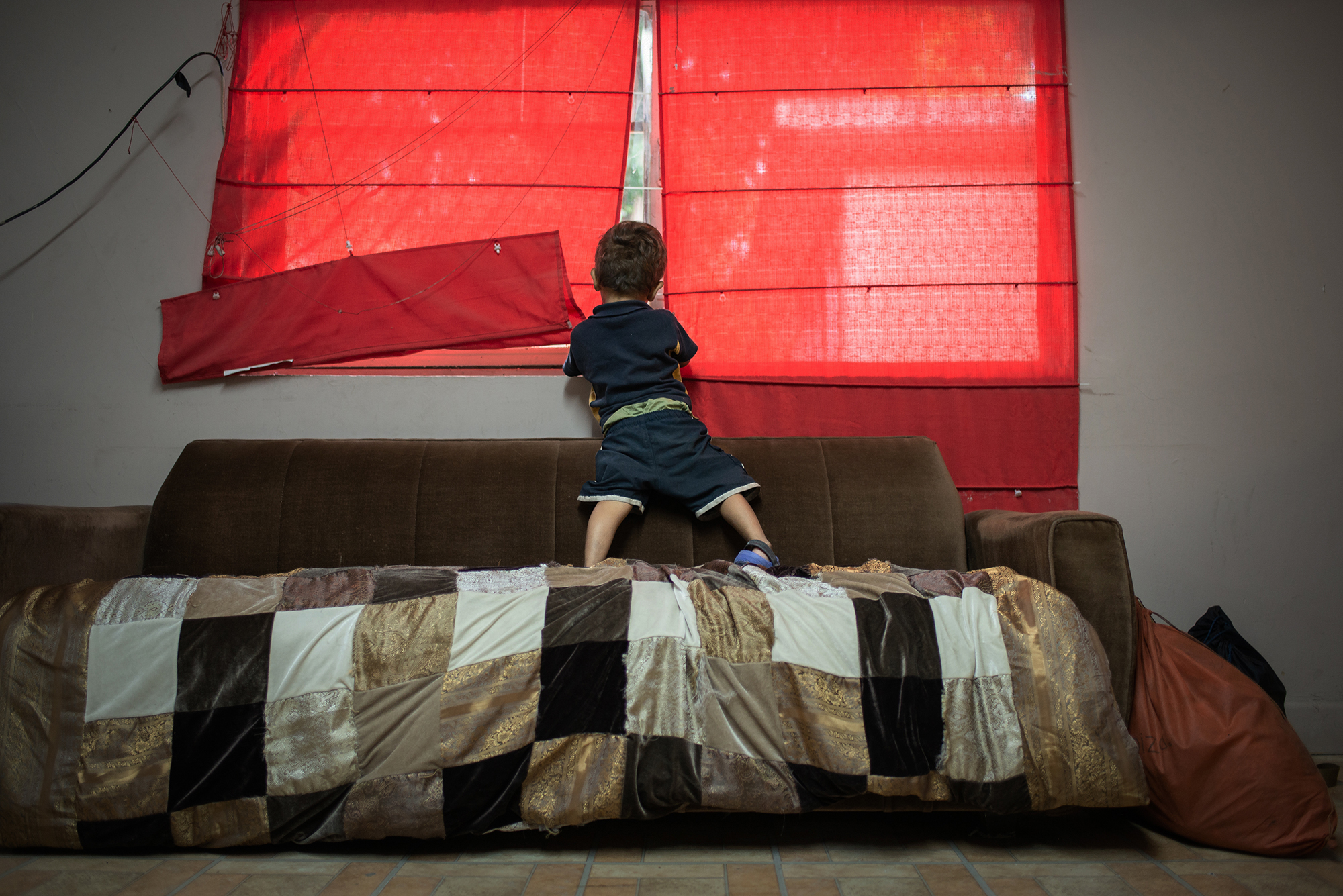  Denis Jose (3 years old), from Honduras looks through the window at "Casa del Migrante Frontera Digna" created by priest Jose Guadalupe Valdes Alvarado. Her mother Diana and him left their homecountry Honduras due to the violent situation her countr