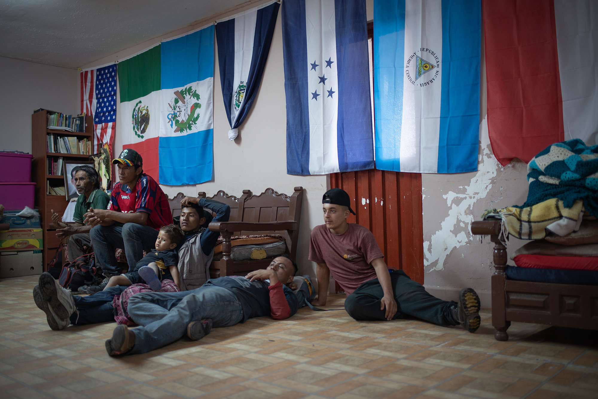  A group of migrants hangs out and watches TV at "Casa del Migrante Frontera Digna" created by priest Jose Guadalupe Valdes Alvarado. "Casa del Migrante Frontera Digna" was created to provide lodging for migrants from different countries who arrive a