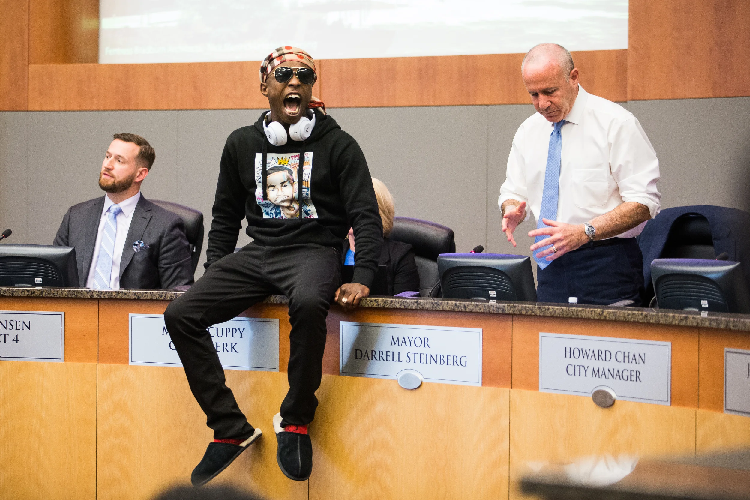 Stephon Clark’s brother, Stevante Clark, angrily jumps onto the desk of Sacramento Mayor Darrell Steinberg during a city council meeting calling for public comment on the police shooting of Clark. Stevante and hundreds of protestors briefly took over both the meeting and City Hall itself.