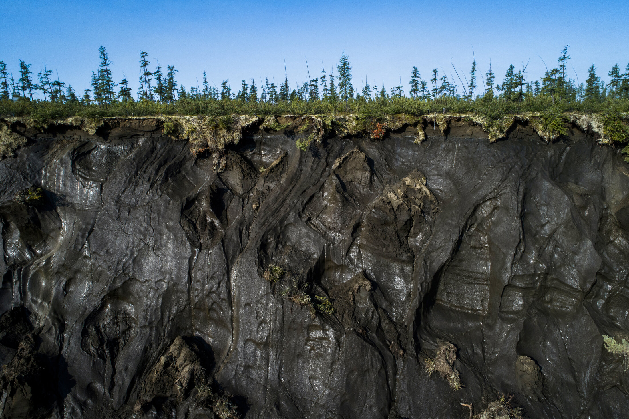  Permafrost along the perimeter of the Batagaika Crater in the Siberian town of Batagay, Russia. It has been called the "hell crater" or the "gateway to the underworld.Ó Over 300 feet deep and 1 kilometer long, this thermokarst depression is one of t