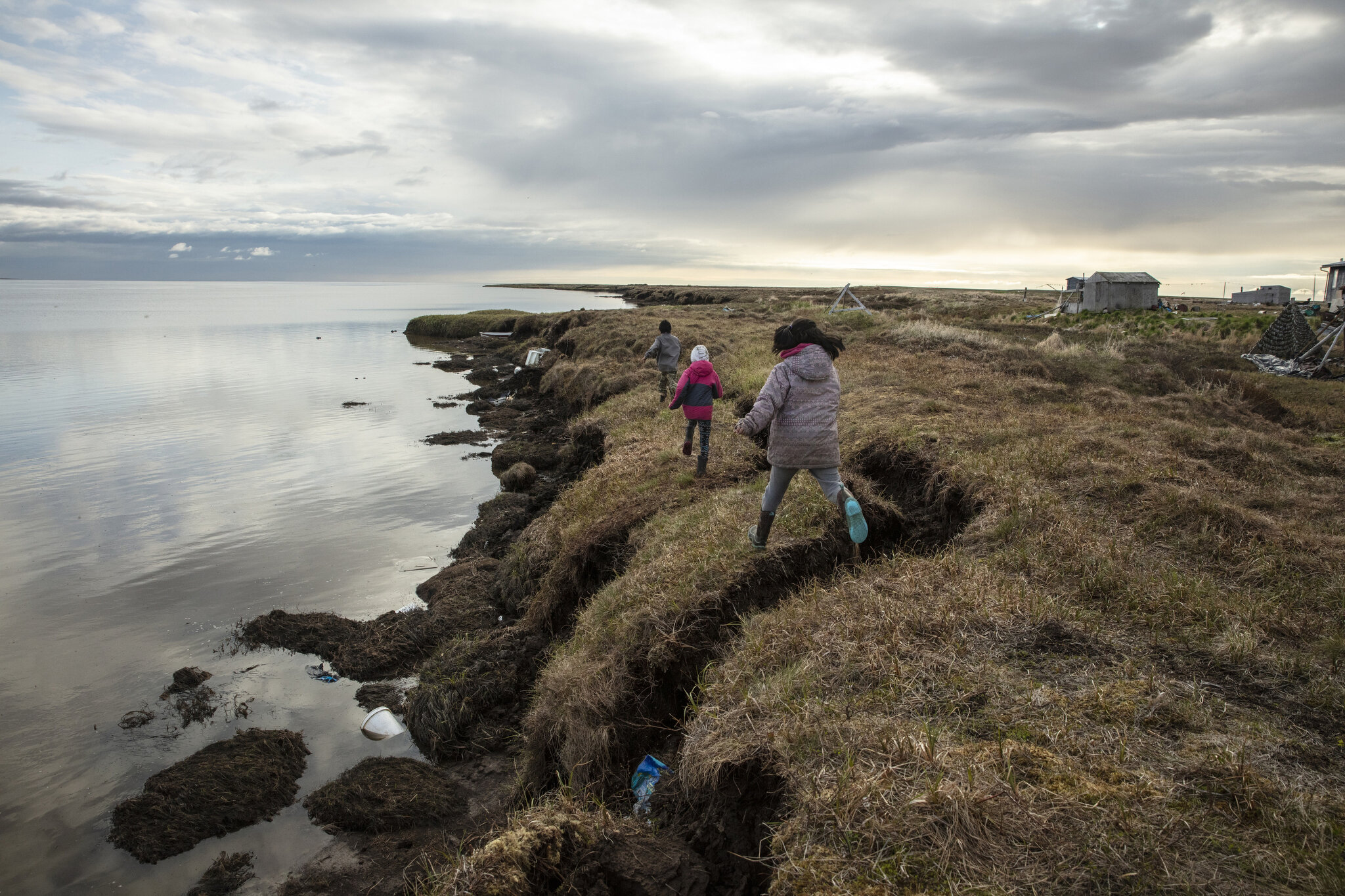  Children in Newtok, Alaska, play near crumbling permafrost cliffs that are now within a few dozen feet of numerous homes. While I was photographing there, multiple unsafe homes were being demolished, and a handful of families were in the process of 