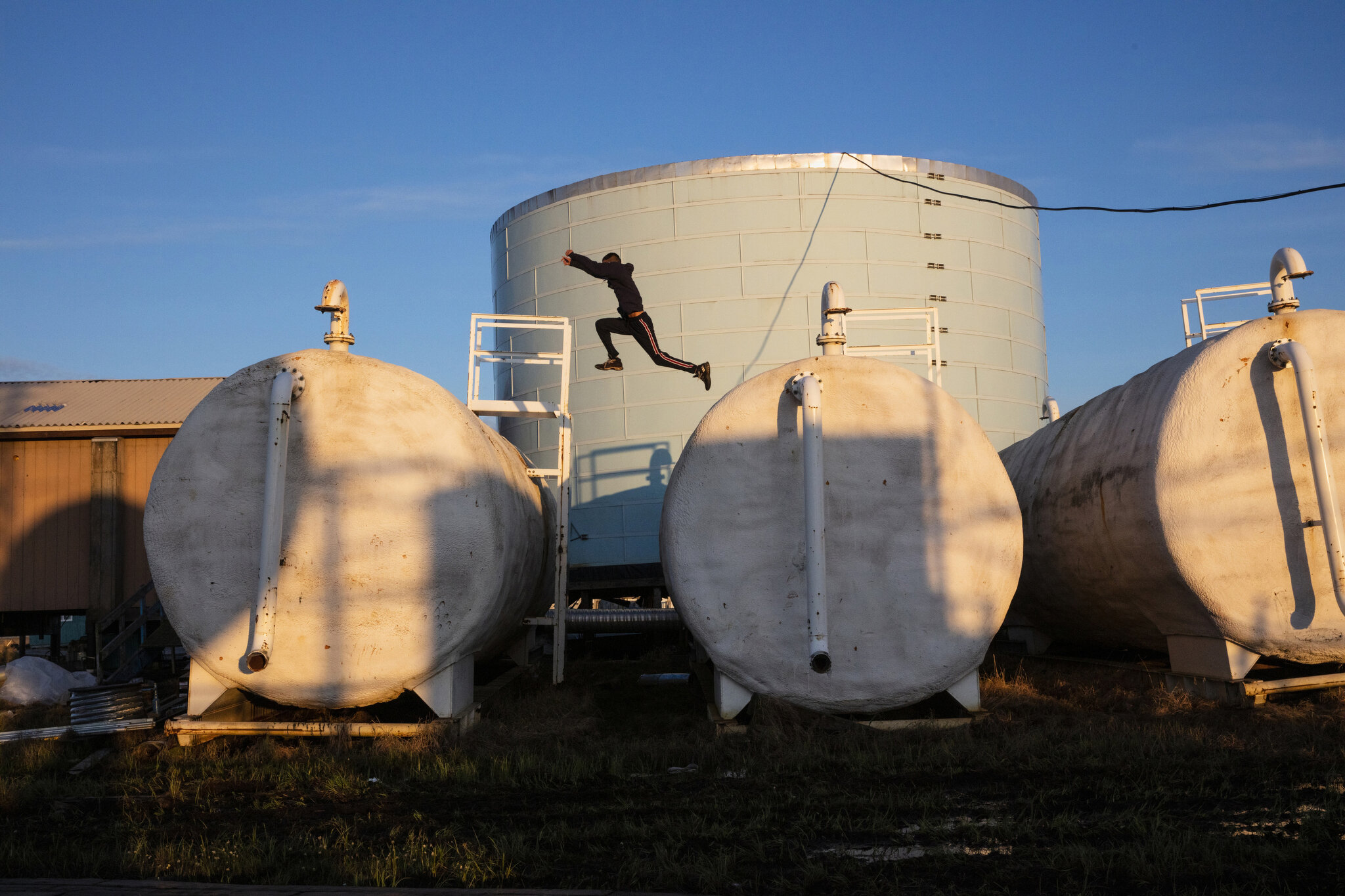  Children play on top of Newtok, Alaska's aging water treatment facilities. May 27th, 2019. Homes in Newtok do not have running water, plumbing or flush toilets; residents must gather their own water from this facility. However after 20 years of floo