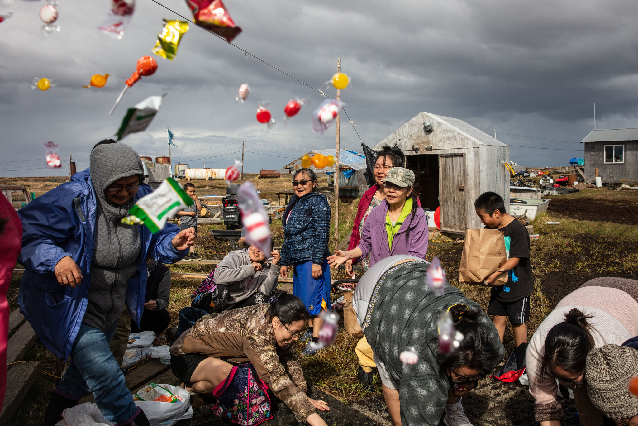  Women gather at the home of Lisa and Jeff Charles in Newtok, Alaska, a Yupik village of roughly 380 people,  for a traditional hunting celebration after their daughter Rayna's first successful ptarmigan hunt. The Charles family gifted the birds to e