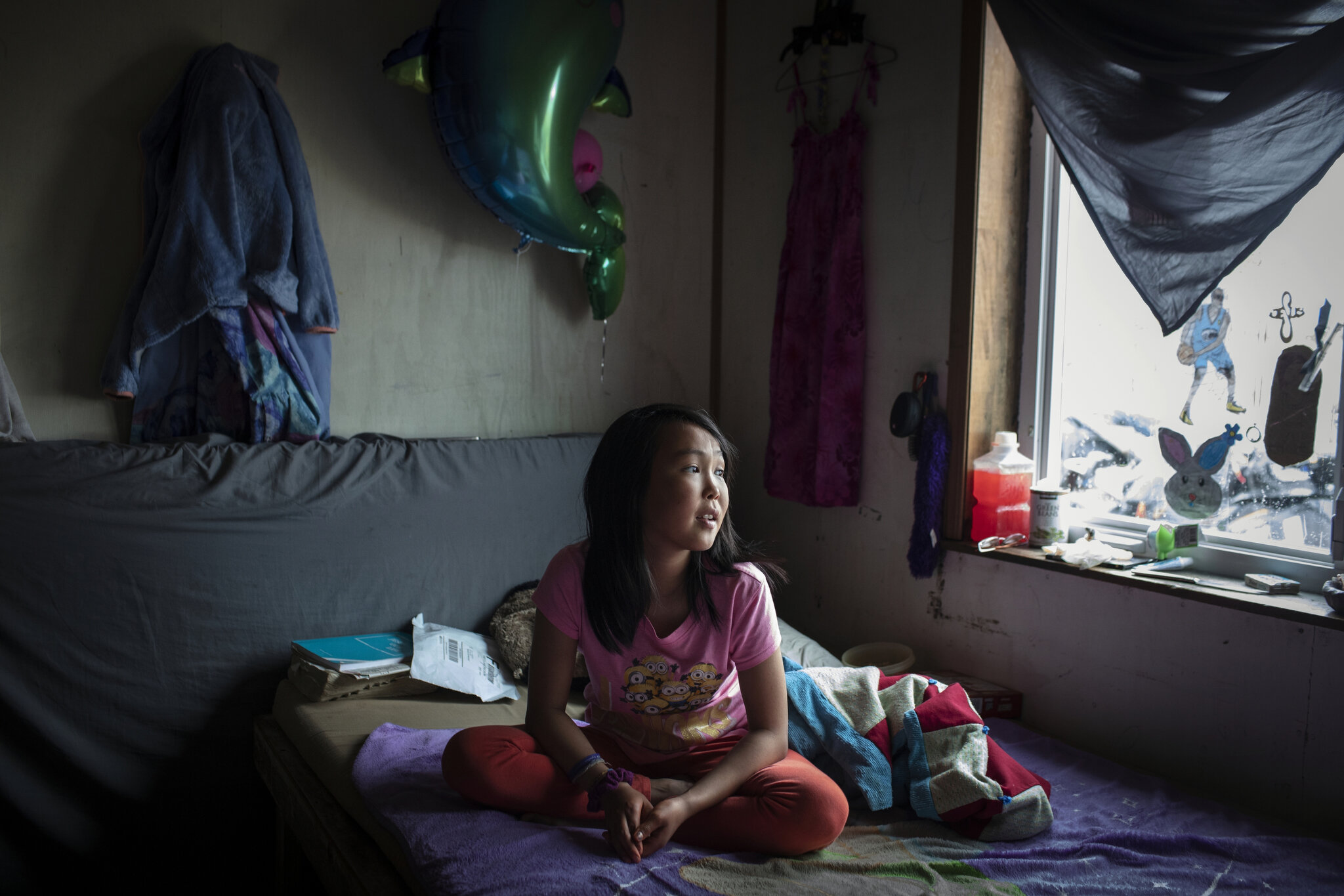  Jasmine Kassaiuli in her bedroom in Newtok, Alaska. Her ceiling recently split in two as a result of thawing permafrost underneath the ground destroying the house's foundation. May 27th, 2019. The Yupik village of Newtok, Alaska, population 380, is 