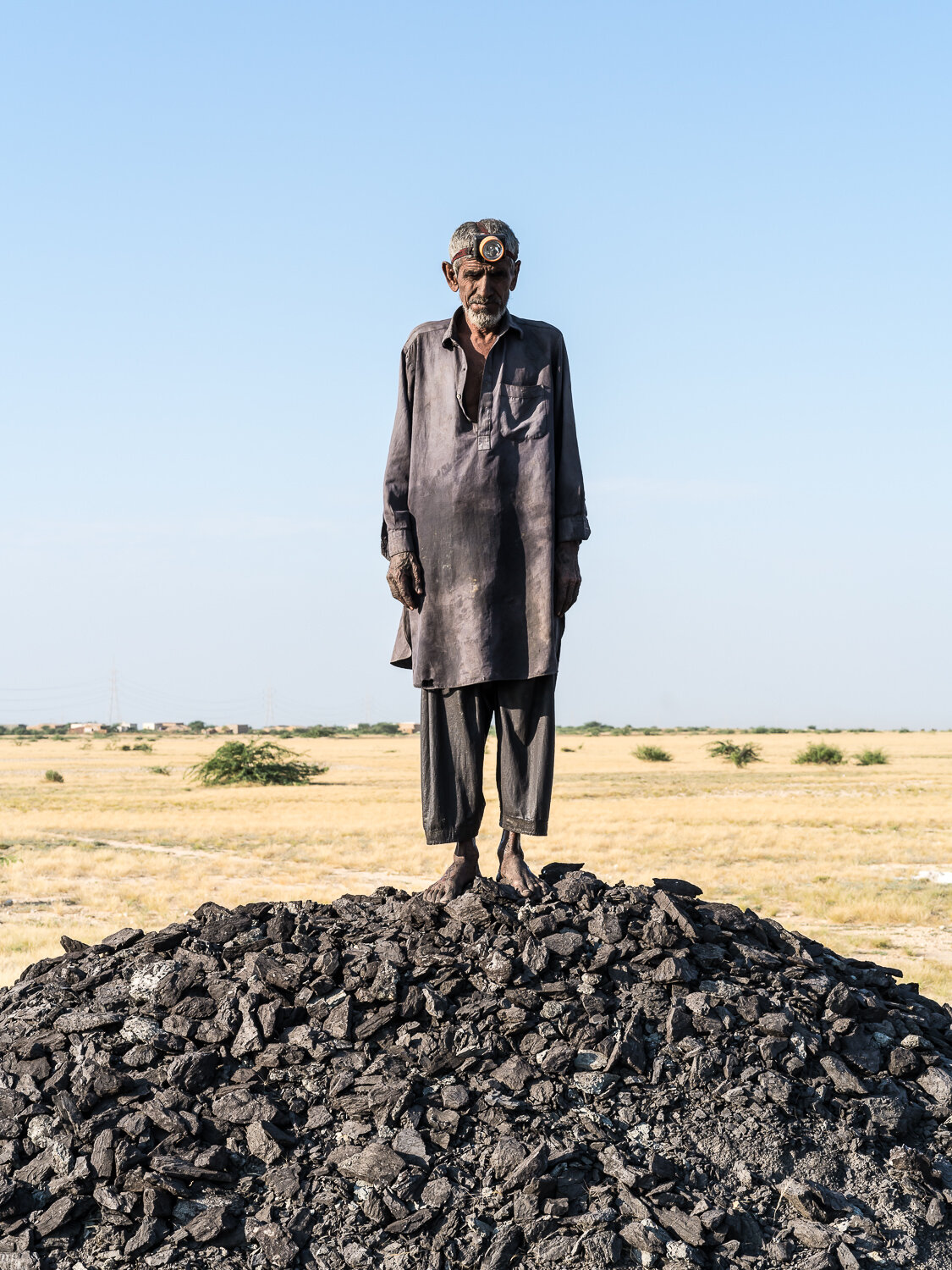  Jan Muhammad Khaskheli, 65, poses for a portrait at the Lucky Coal Mine where he has worked for the past three years on Monday, October 14, 2019 in Jhampir, Sindh, Pakistan. Before working as a coal miner, Khaskheli was a lifelong fisherman on Lake 