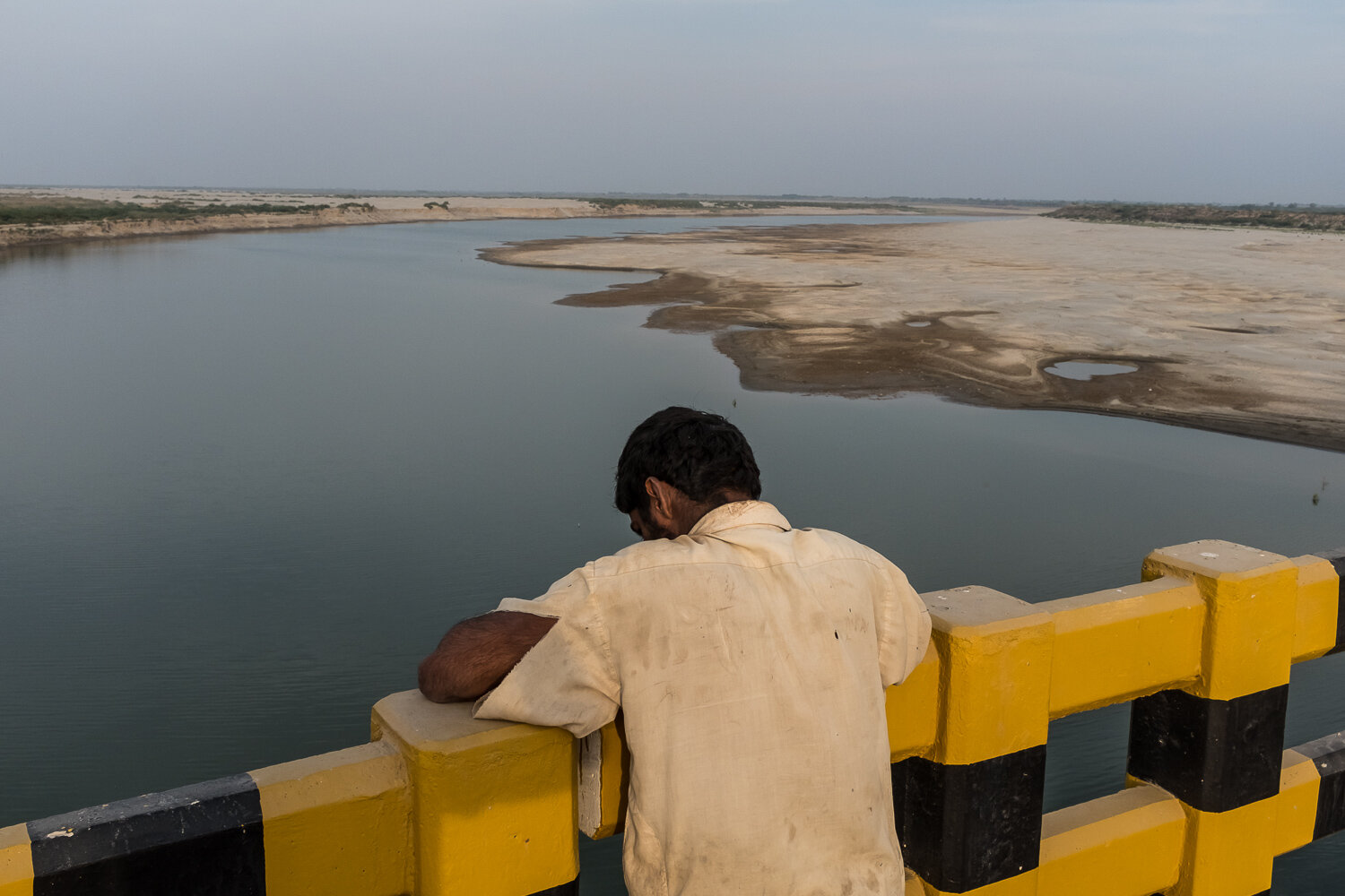  A man looks out from a bridge at the lower Indus River at dusk on Saturday, December 2, 2017 near Thatta, Sindh, Pakistan. 