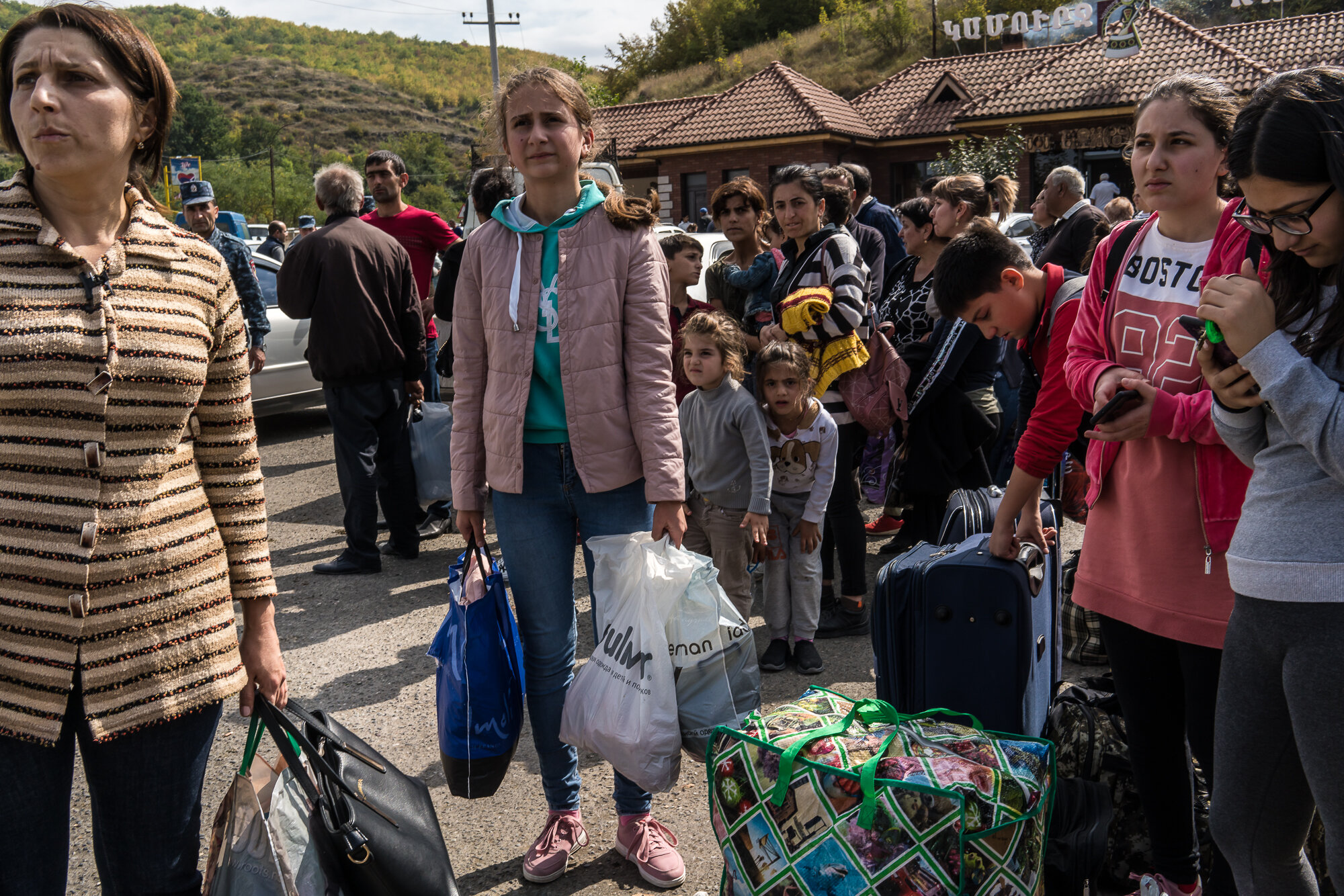  People gather at the edge of the city seeking rides in the direction of Yerevan, away from fighting. Stepanakert, Nagorno-Karabakh. 2020. 