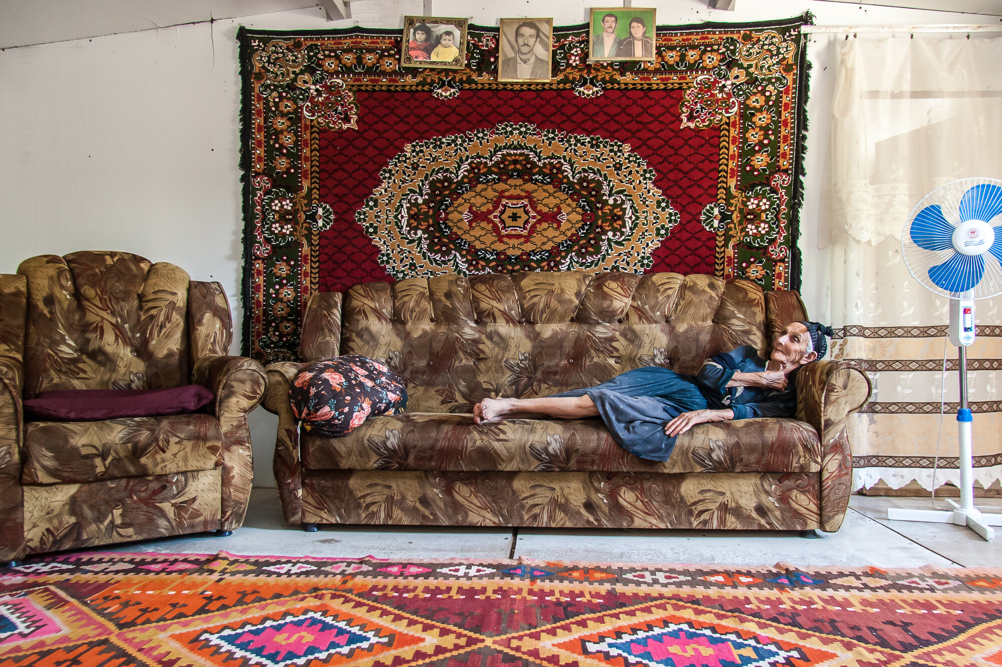  An old woman stops for a rest in her home in the Chalabixan camp for internally displaced people from Nagorno-Karabakh. Sheki area, Azerbaijan. 2006. 