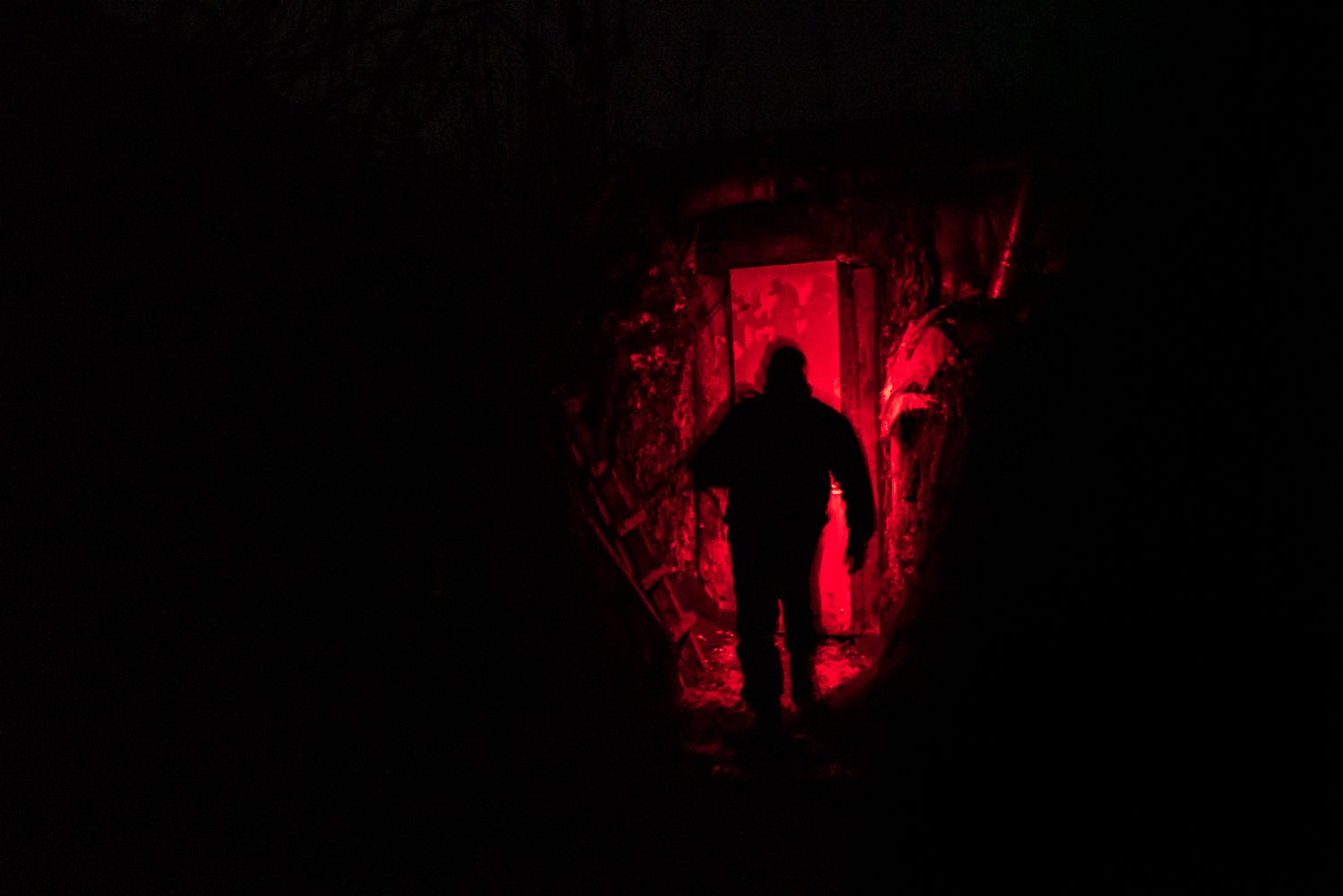  Taras, a Ukrainain Marine from the 503rd Marine Battalion, uses a red light to illuminate his way during a night watch at a front-line position on Monday, February 7, 2022 in Verkhnotoretske, Ukraine. 