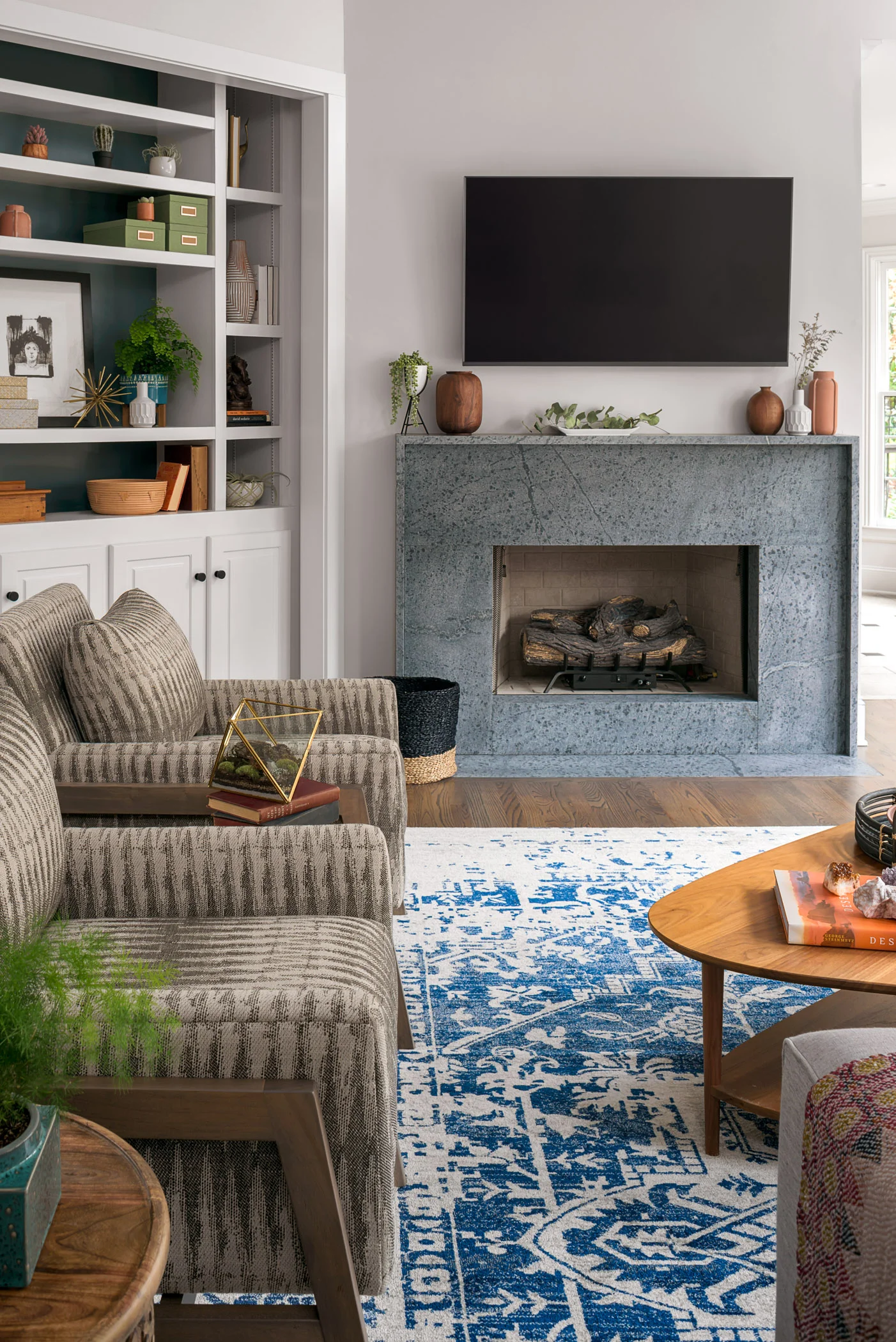 The fireplace in the great room underwent the biggest transformation in this space. We removed the black granite surround and designed a custom soapstone hearth, surround and mantle to create a focal point for the room.