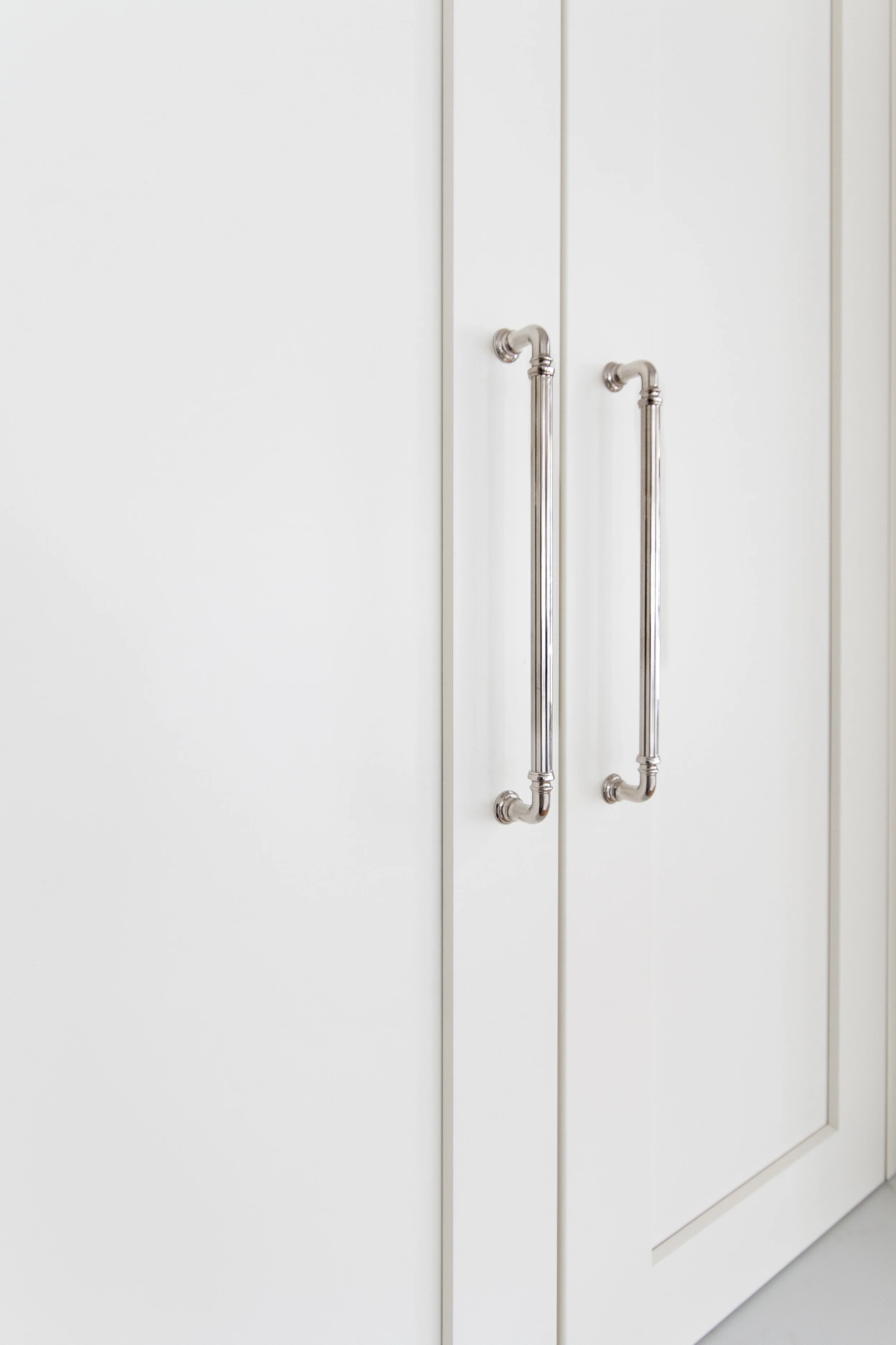 Elegant fluting on the polished nickel cabinet hardware.