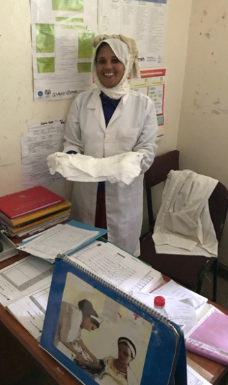 Rahel, a midwife at Ayemba, accepts some SCOPE onesies