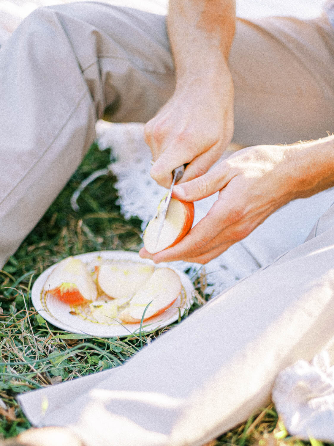 upclose-man-cutting-apple-slice-at-picnic-engagement-session-in-charlottesville-virginia.jpg