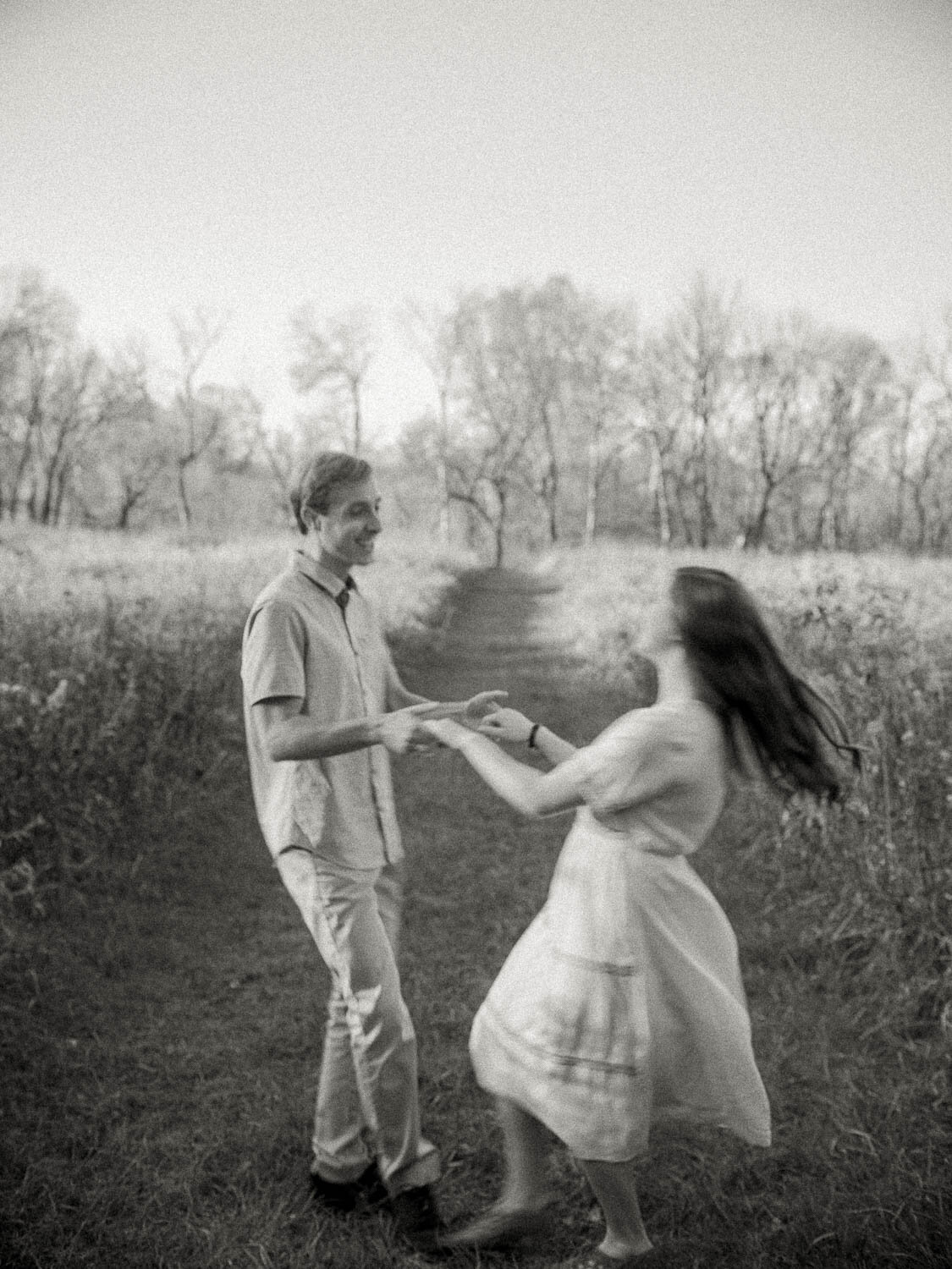man-and-woman-spinning-through-field-during-golden-hour-for-their-fall-engagement-session.jpg