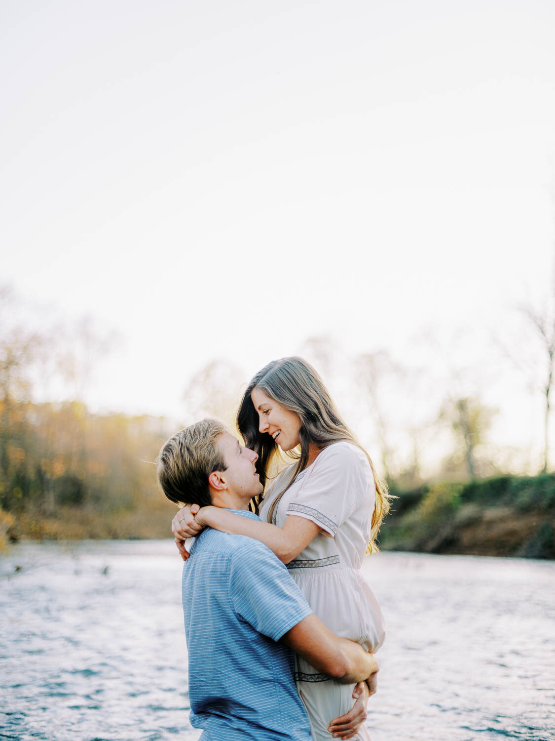 man-picking-up-woman-romantically-while-standing-in-rivanna-river-during-fall-engagement-session-at-golden-hour-in-charlottesville-virginia.jpg