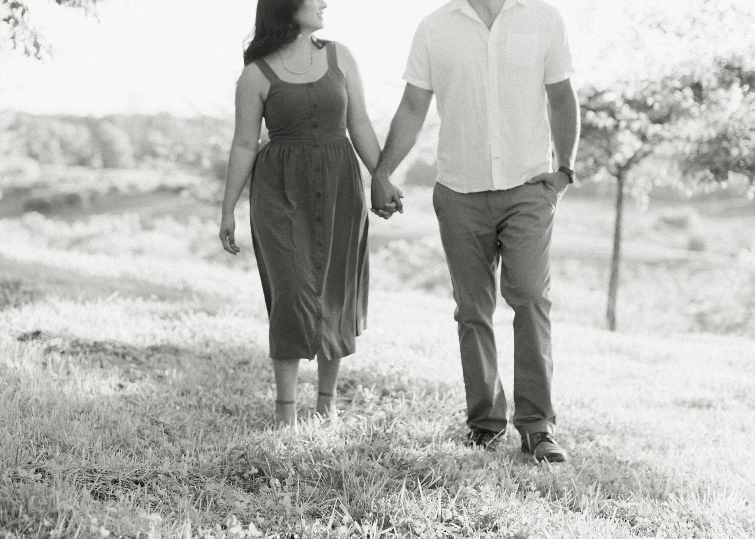 black-and-white-shot-of-couple-walking-in-orchard-at-market-at-grelen-charlottesville.jpg