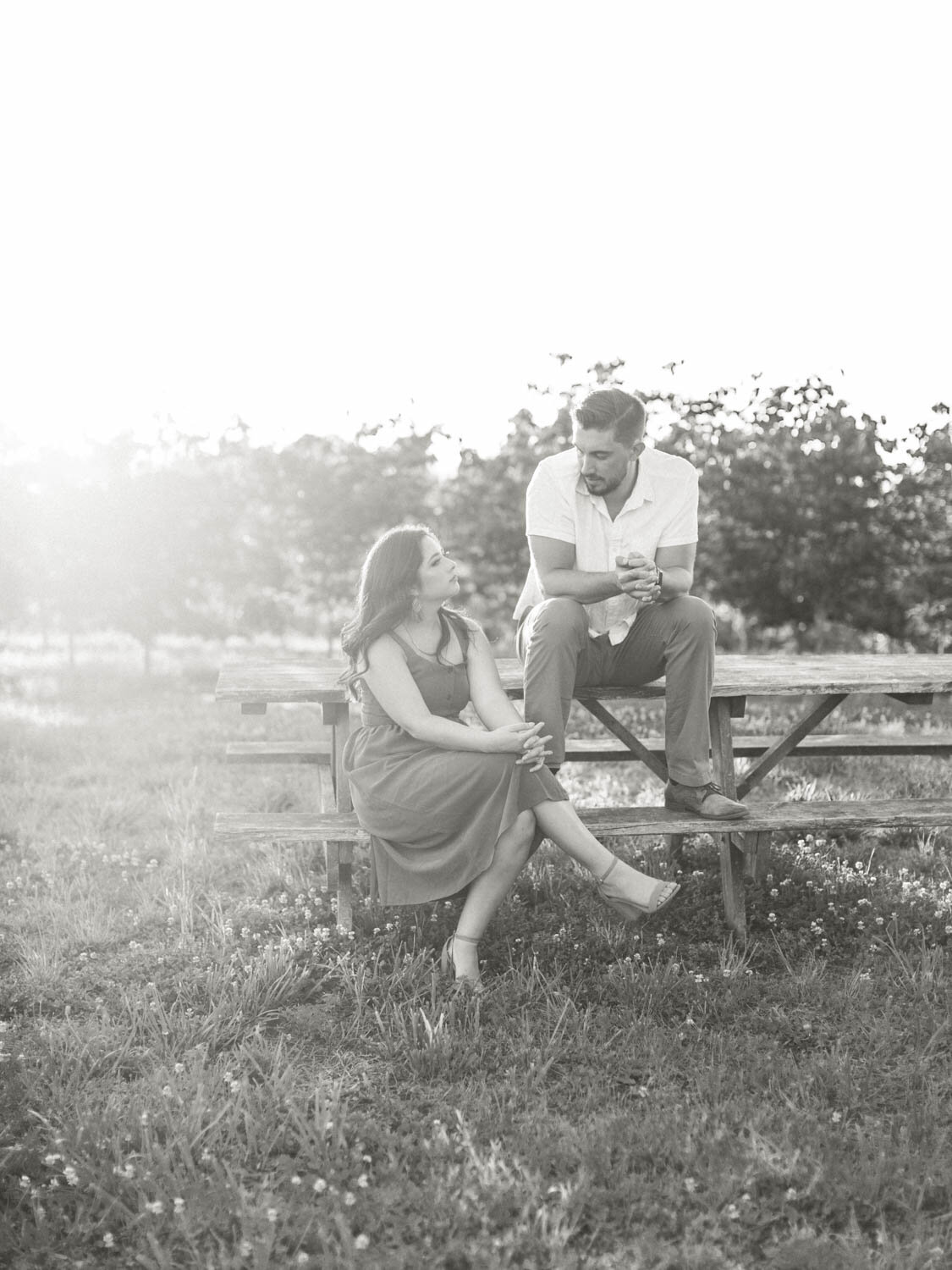 black-and-white-shot-of-couple-sitting-on-park-bench-at-market-at-grelen-charlottesville.jpg