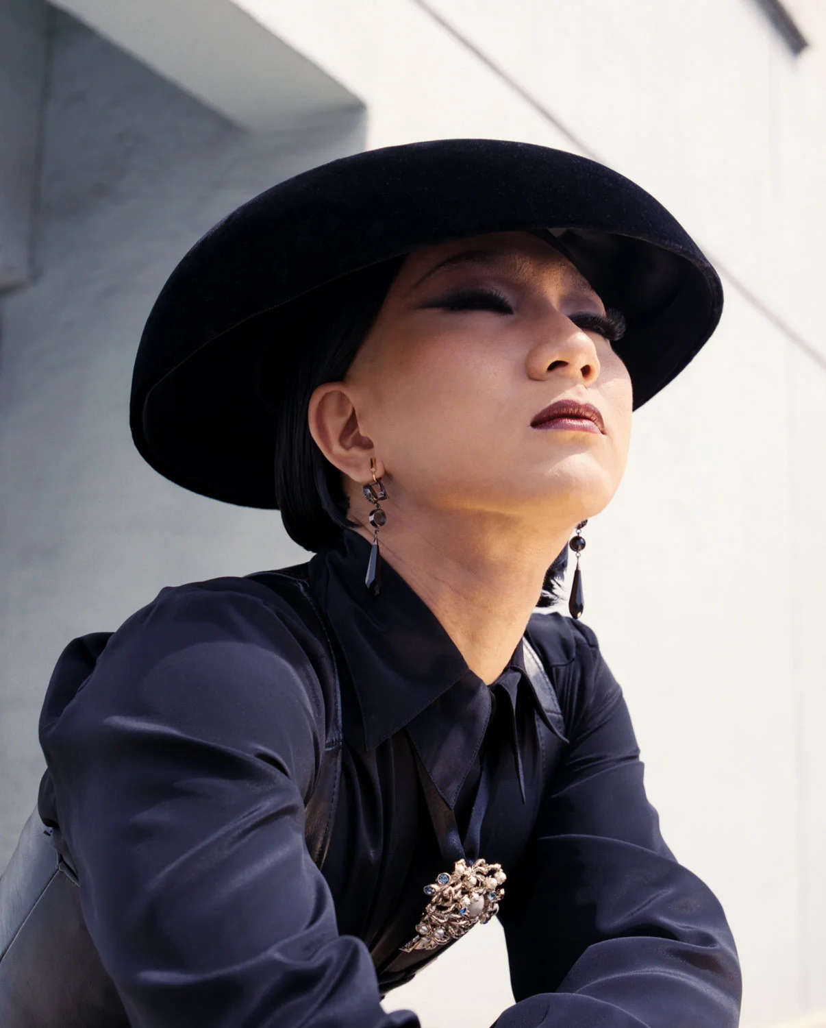 Vintage vest — Cherry Vintage; Vintage shirt — Screaming Mimi’s; Vintage hat — Cherry Vintage; Necklace — Koché; Earrings — Givenchy