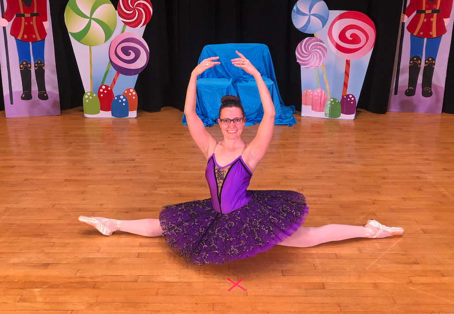 Ella Rosewood in the splits wearing pink tights, pointe shoes, and a purple tutu.