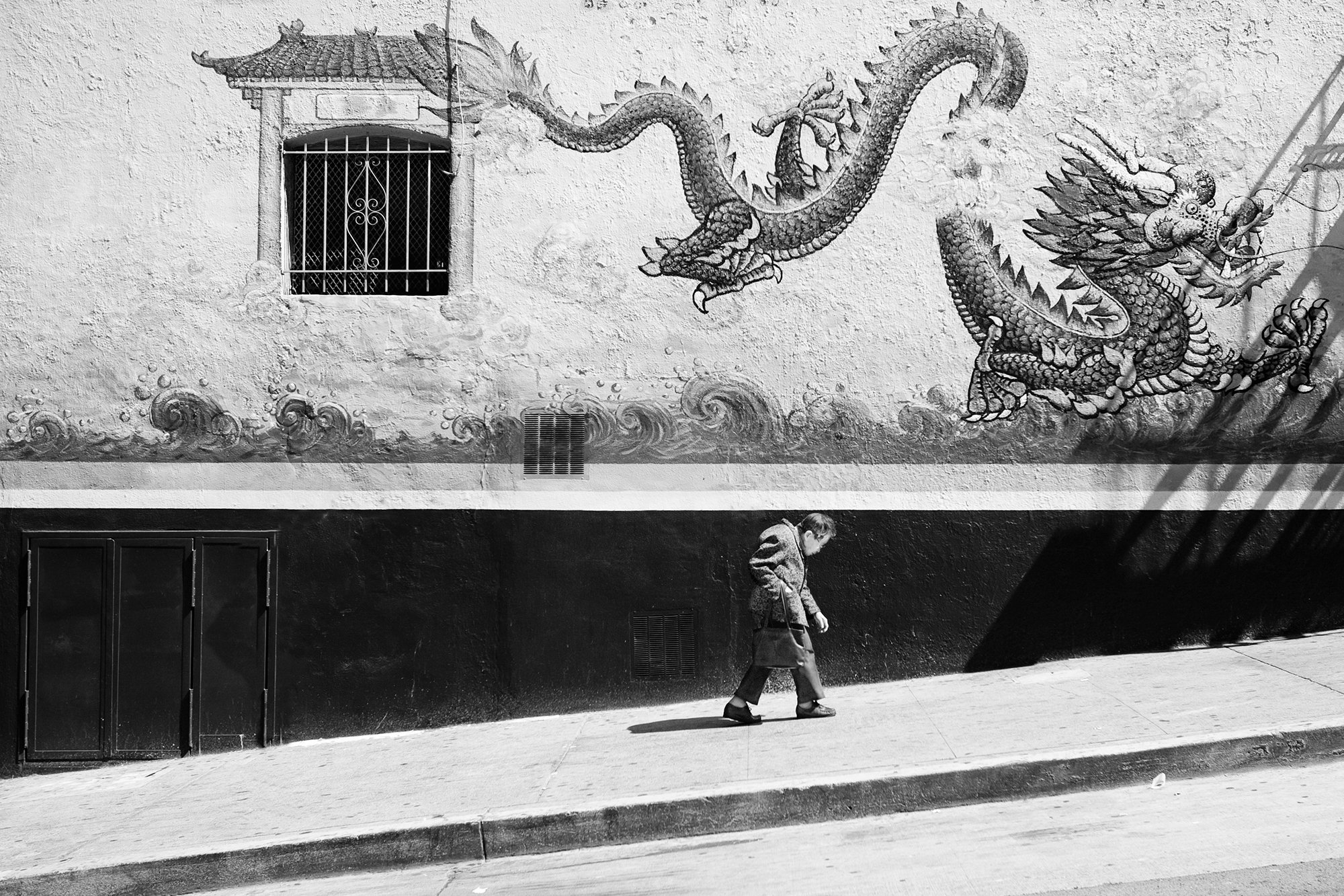 Old lady climbing a hill in Chinatown, San Francisco, California, USA